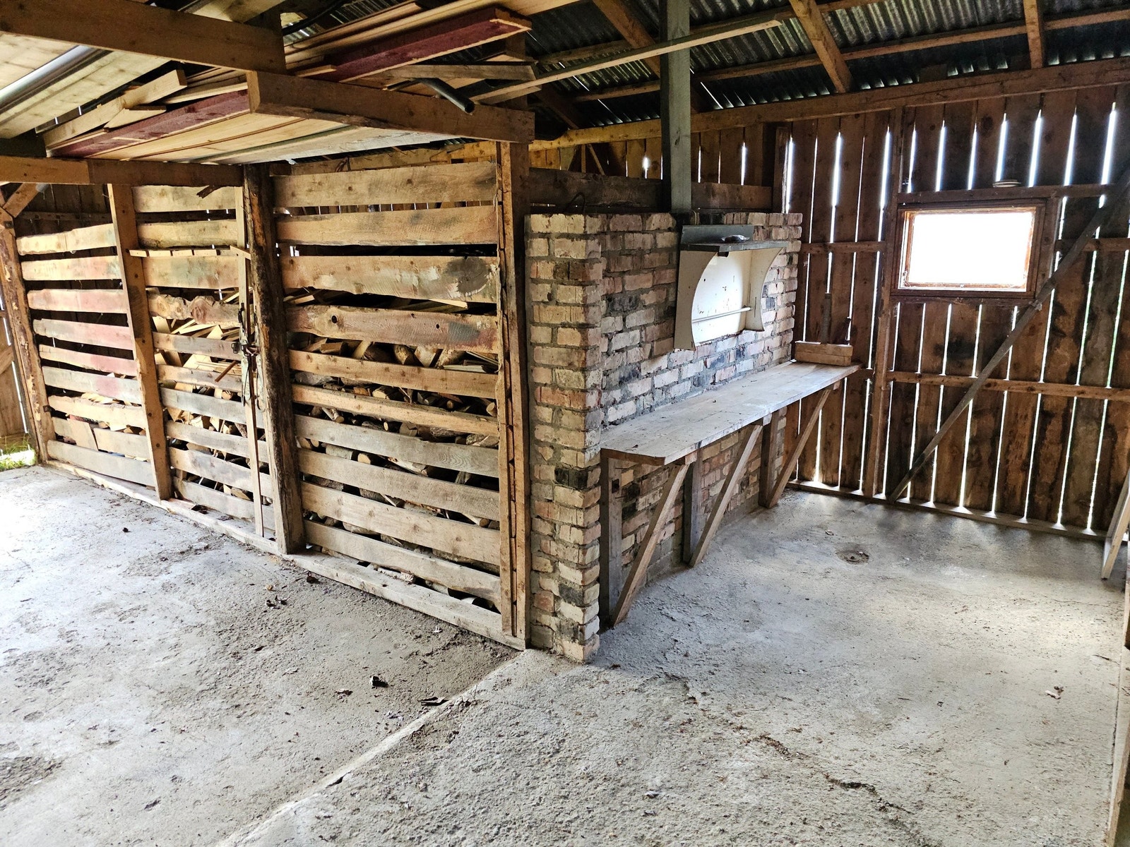Uthus med liten garasjeplass, skåle og snekkerbenk. Galleribilde