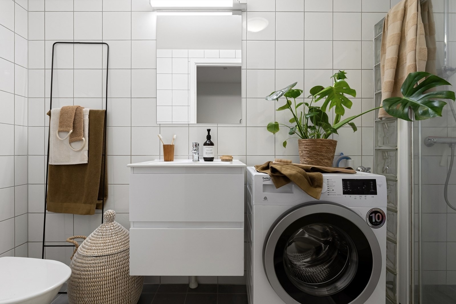 Bad fra 2003 med dusjnisje med dusjskillevegg i herdet glass, servant med underskuffer, gulvmontert toalett og opplegg for vask/tørk. Galleribilde