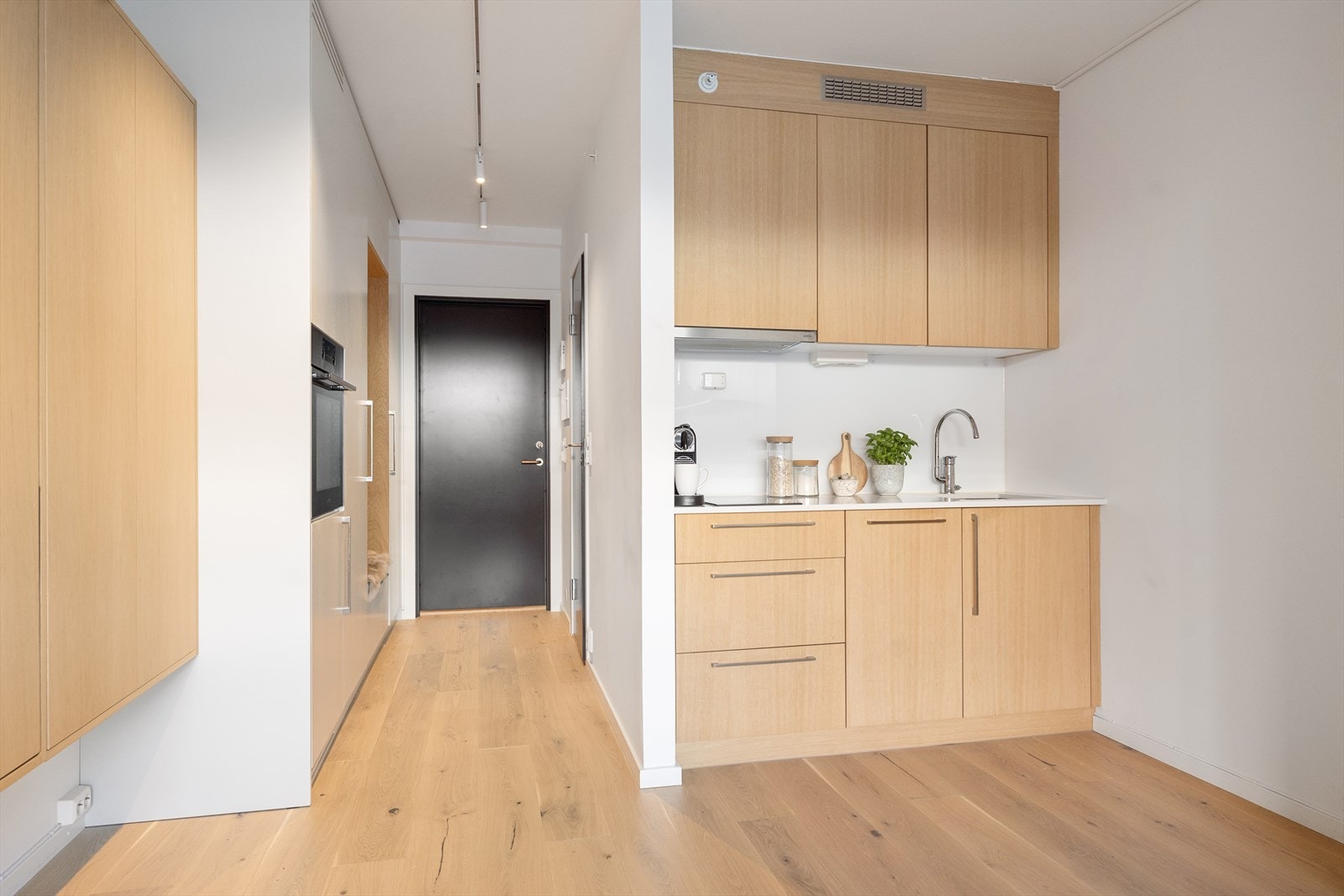 Kjøkkeninnredning med glatte fronter og ventilator med avtrekk ut. Galleribilde
