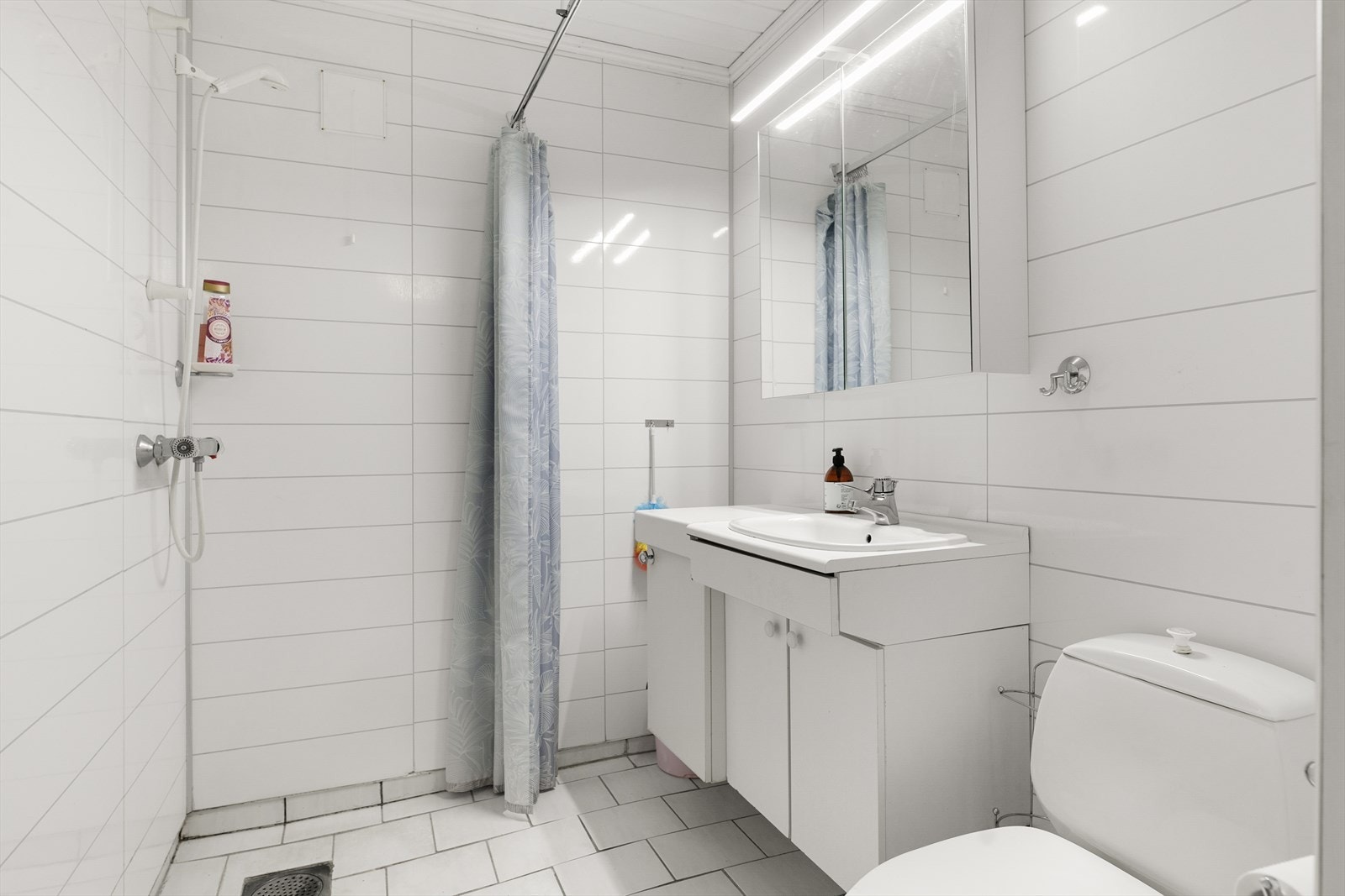 Badet i underetasjen er fra byggeåret og har flislagt gulv, våtromsplater på veggene og dusj på gulv. Galleribilde