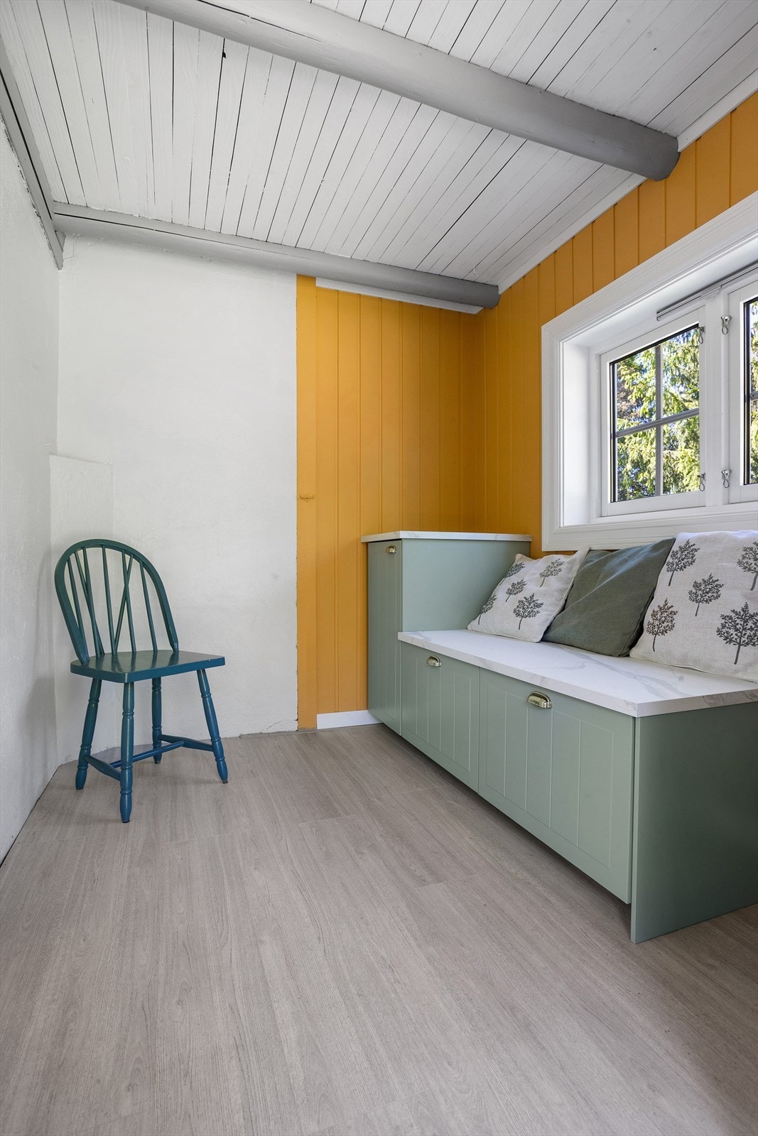 Man kommer inn i en lys entré med laminatgulv og malt panel på veggene. Galleribilde
