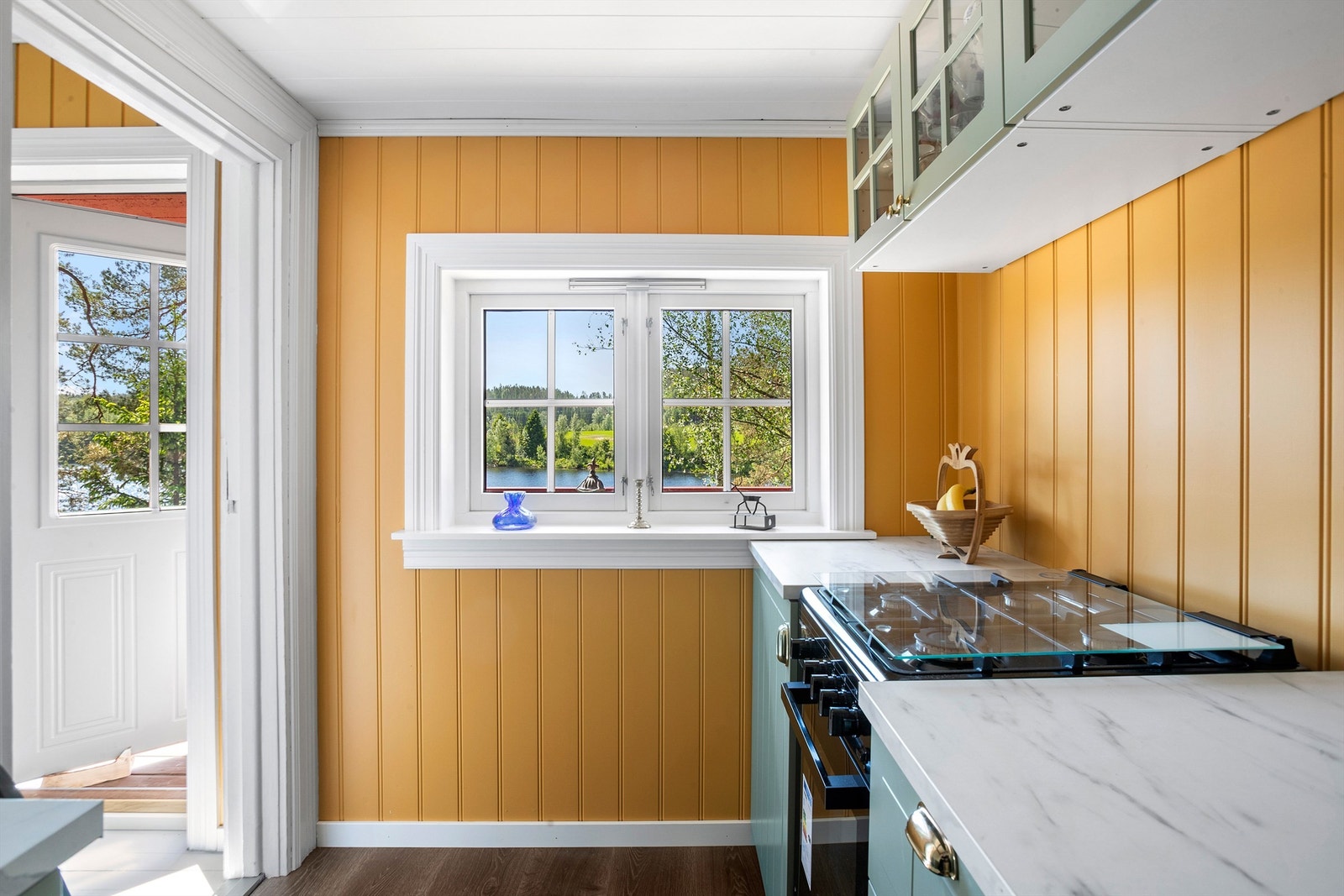 Fra kjøkkenet er det utsikt mot vannet og enkel adkomst til stuen og uteområdet. Galleribilde