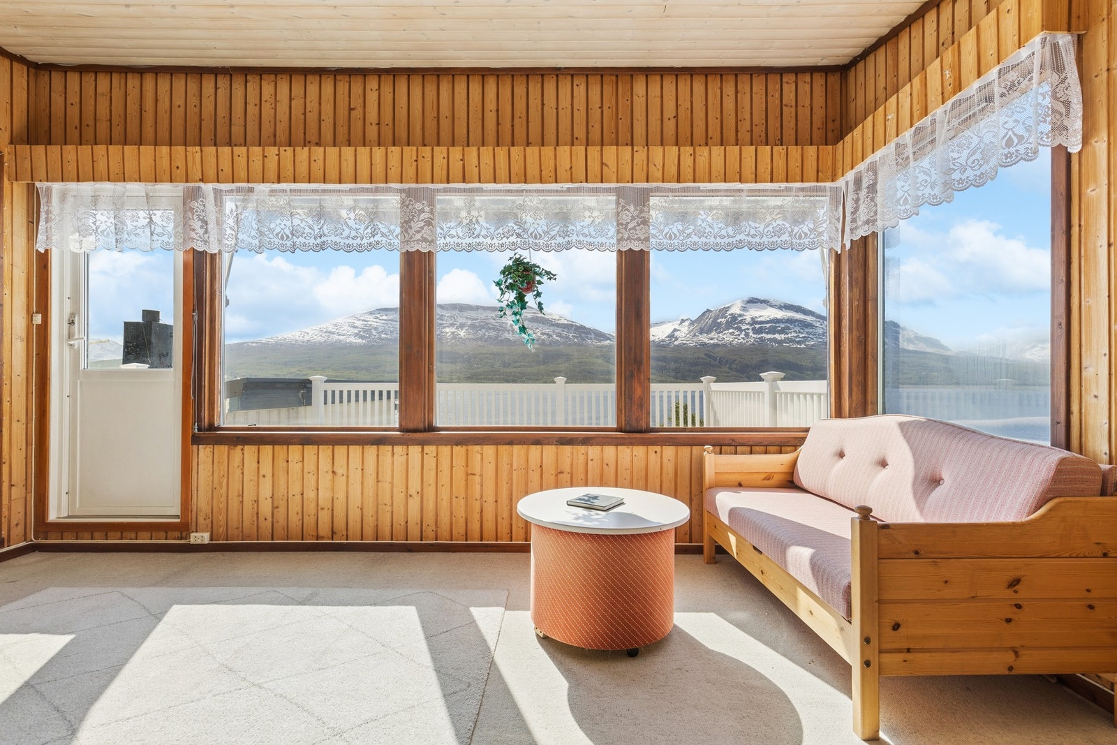 Loftstue med store vindusflater som gir en åpen utsikt mot fjorden. Galleribilde