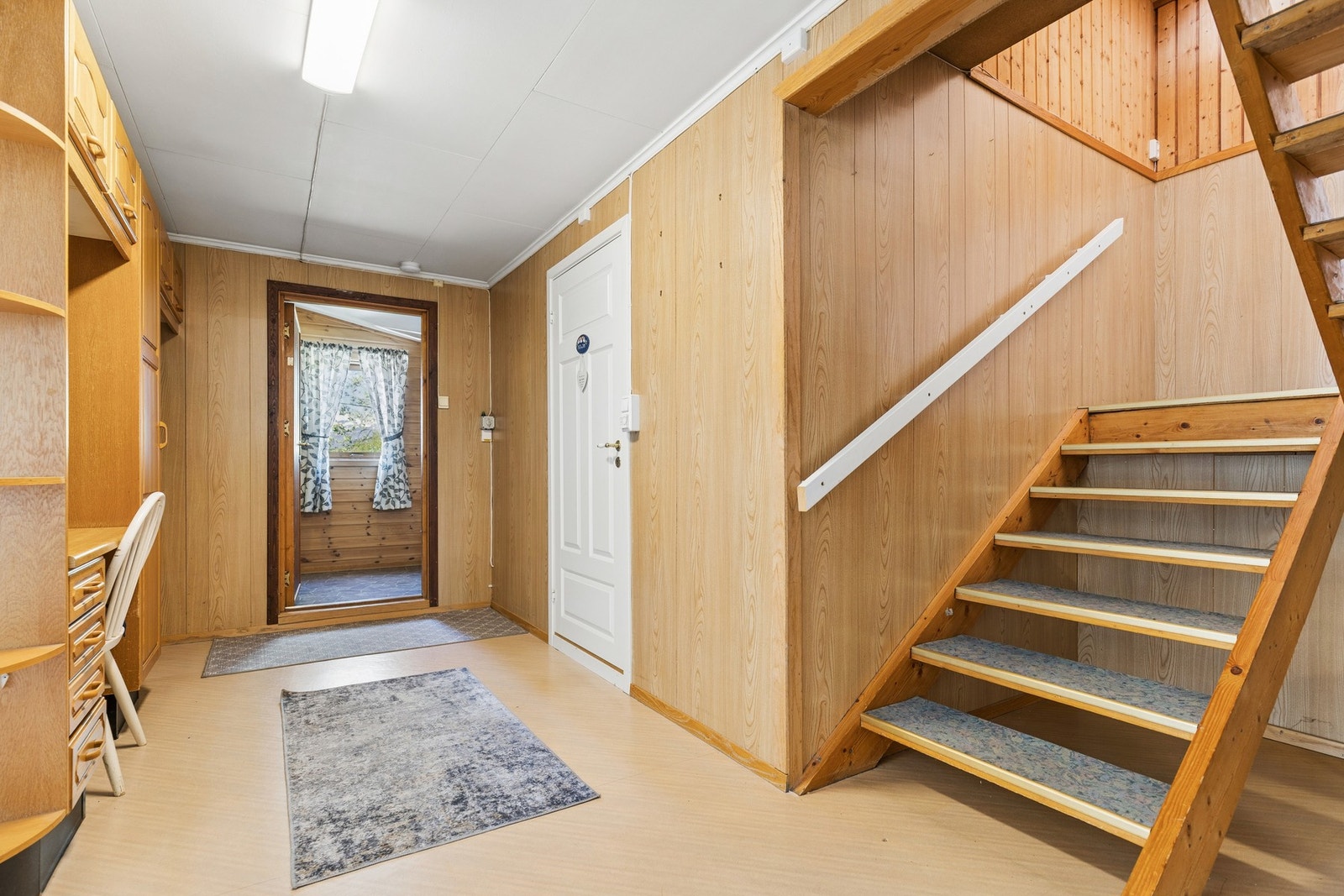Entré med trappeforbindelse til andre etasje og plassbygde hyller for oppbevaring. Galleribilde