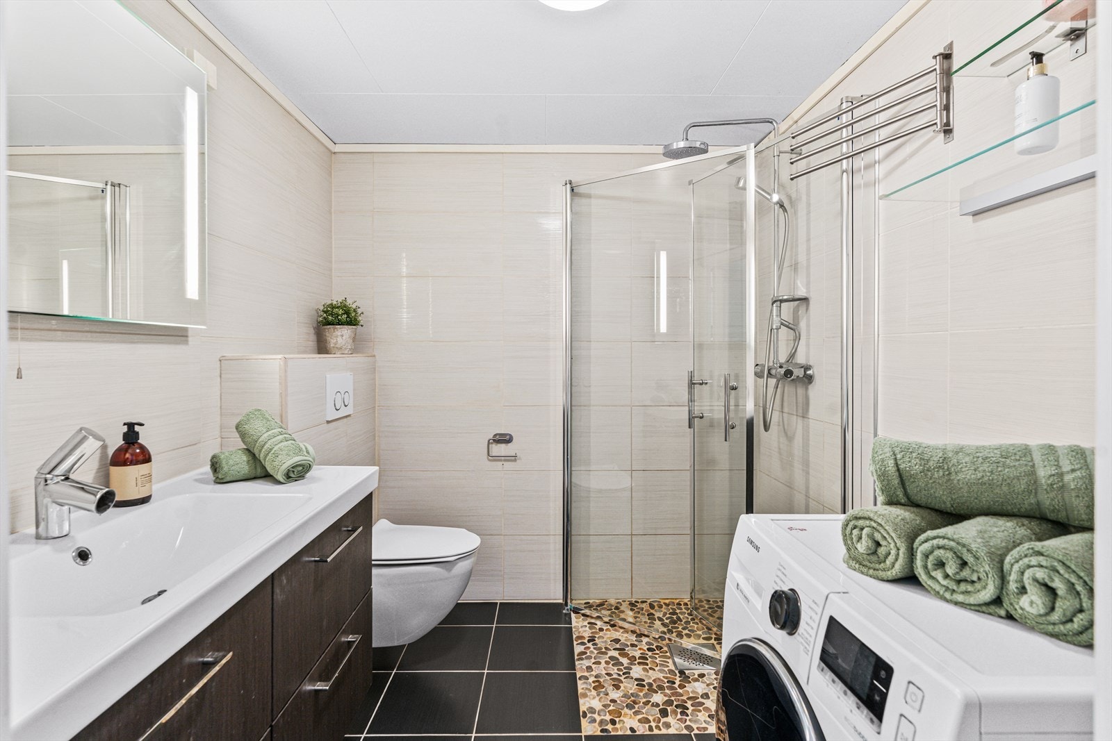 Badet fra 2012 er pent utført med mørke fliser på gulvet, lysbeige veggfliser, rullesteiner på gulvet i dusjsonen og gulvvarme. Badet har også opplegg for vaskemaskin. Galleribilde