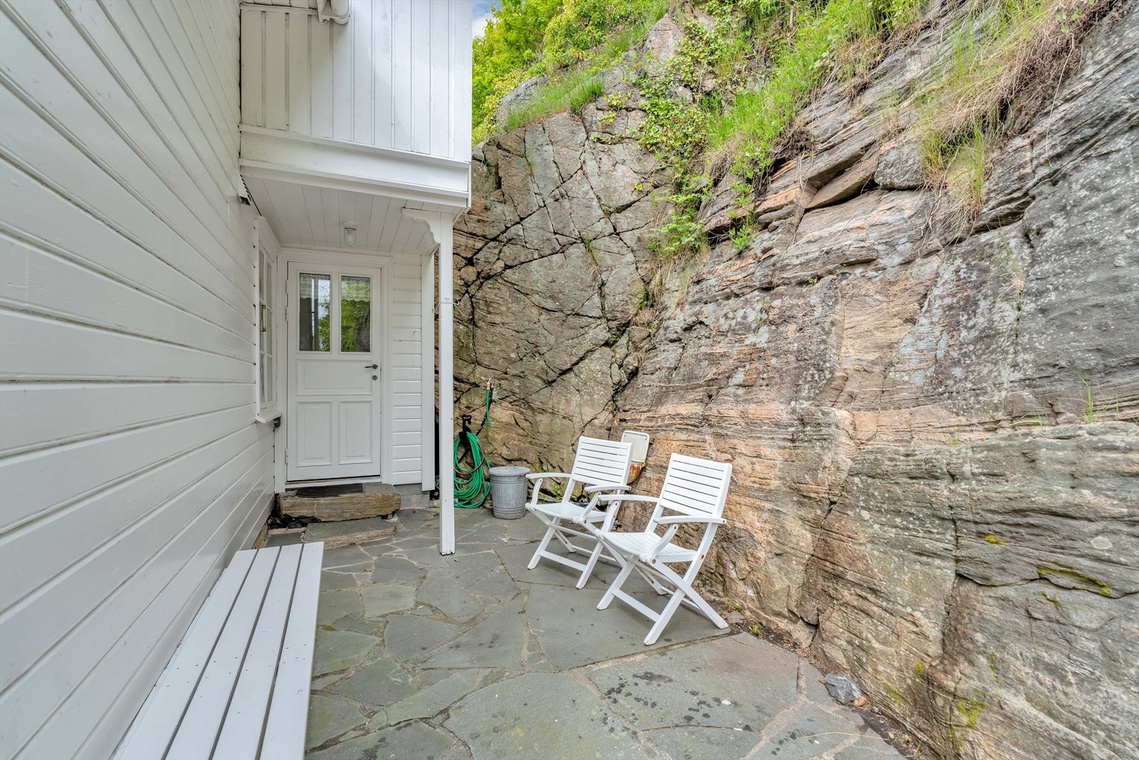 En skjermet uteplass med skiferheller, tett på fjellet. Galleribilde