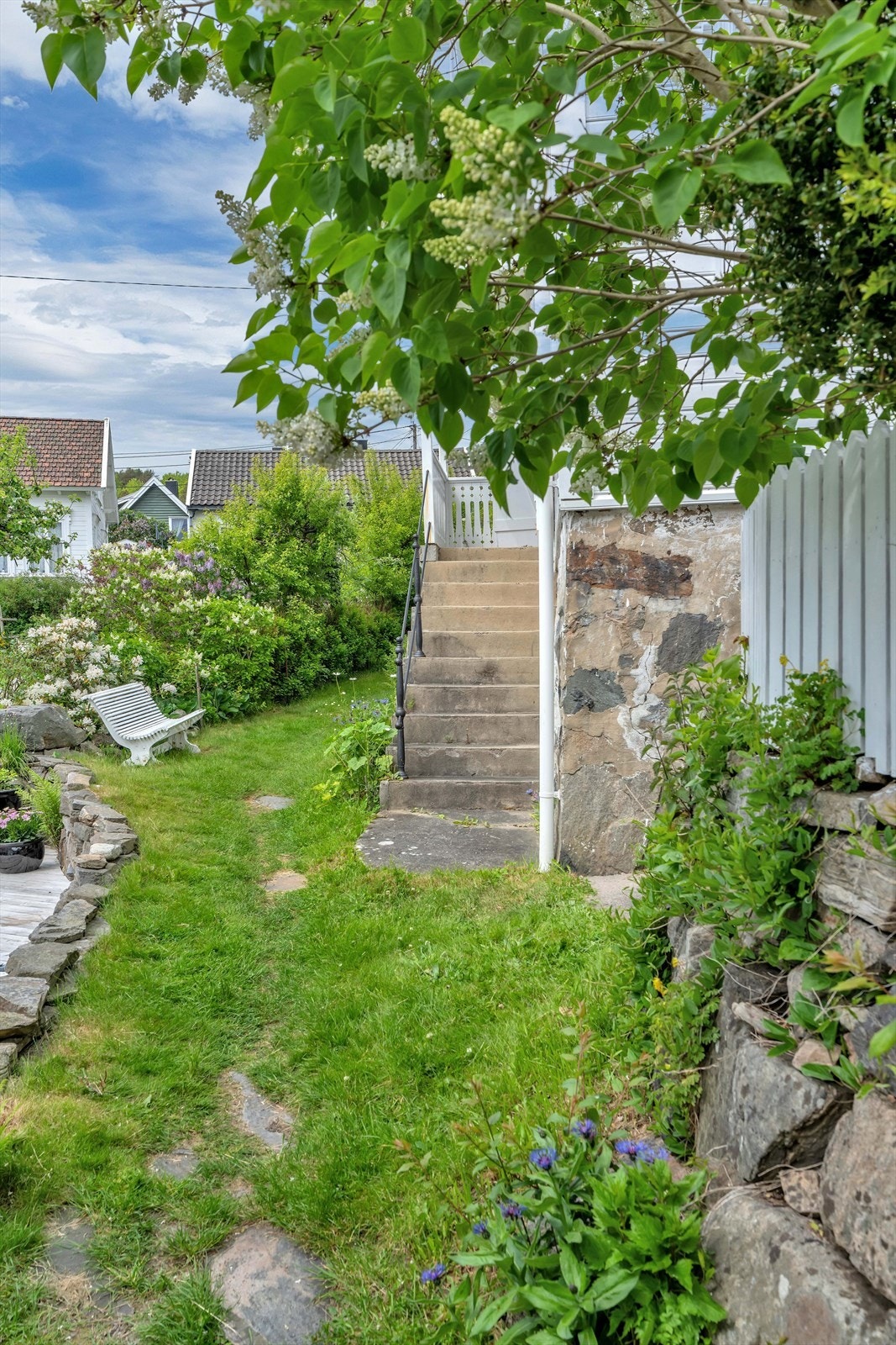Tomten er opparbeidet med plen, beplantning og gangstier. Galleribilde