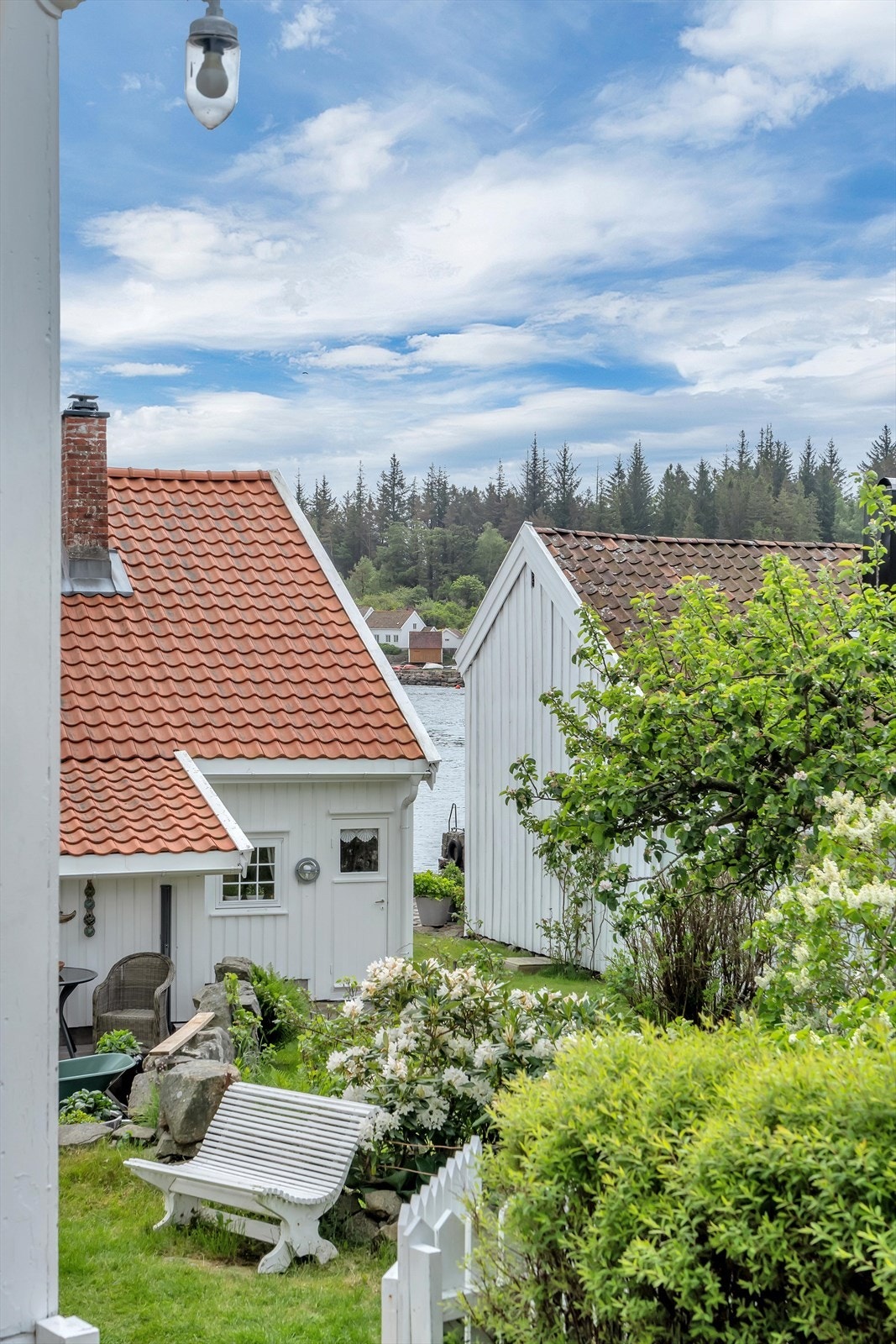 Utsikt fra eiendommen mot nabobebyggelsen og sjøen. Galleribilde