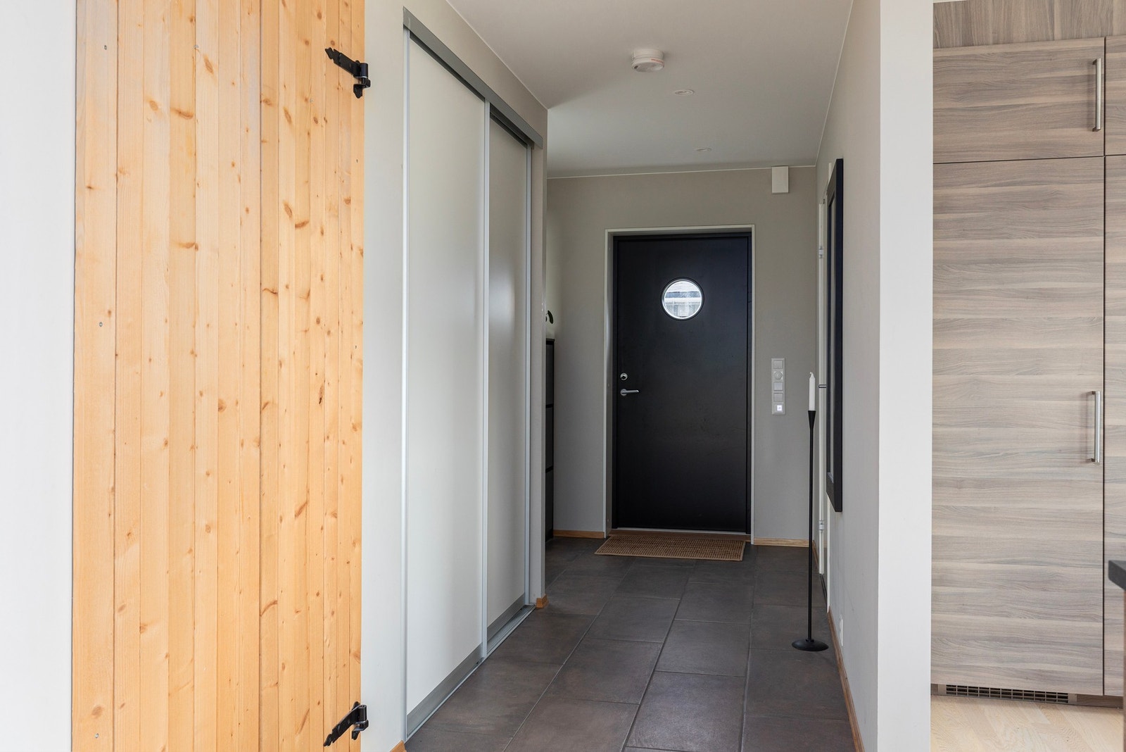 Flislagt gang mot entréen, også her medvarme i gulv. Praktisk skyvedørsgarderobe idet man kommer inn i gangen. Galleribilde