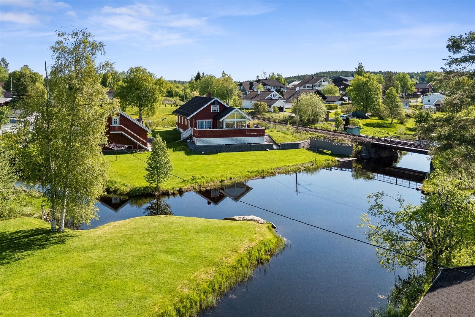 Tomten er opparbeidet med plen og beplantning, og har en gruset gårdsplass. Galleribilde