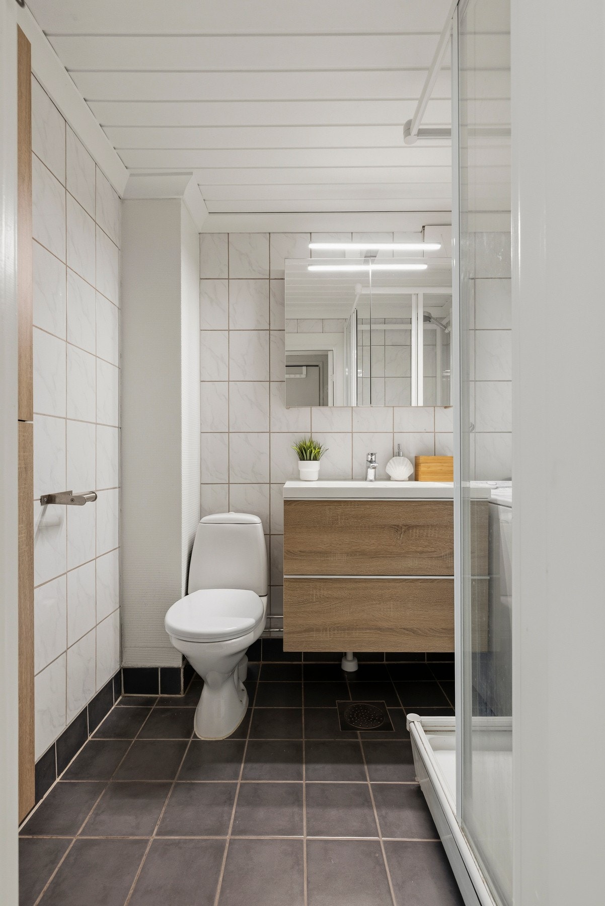 Badet har vegghengt servant på servantskap og vegghengt speilskap 2018. Galleribilde