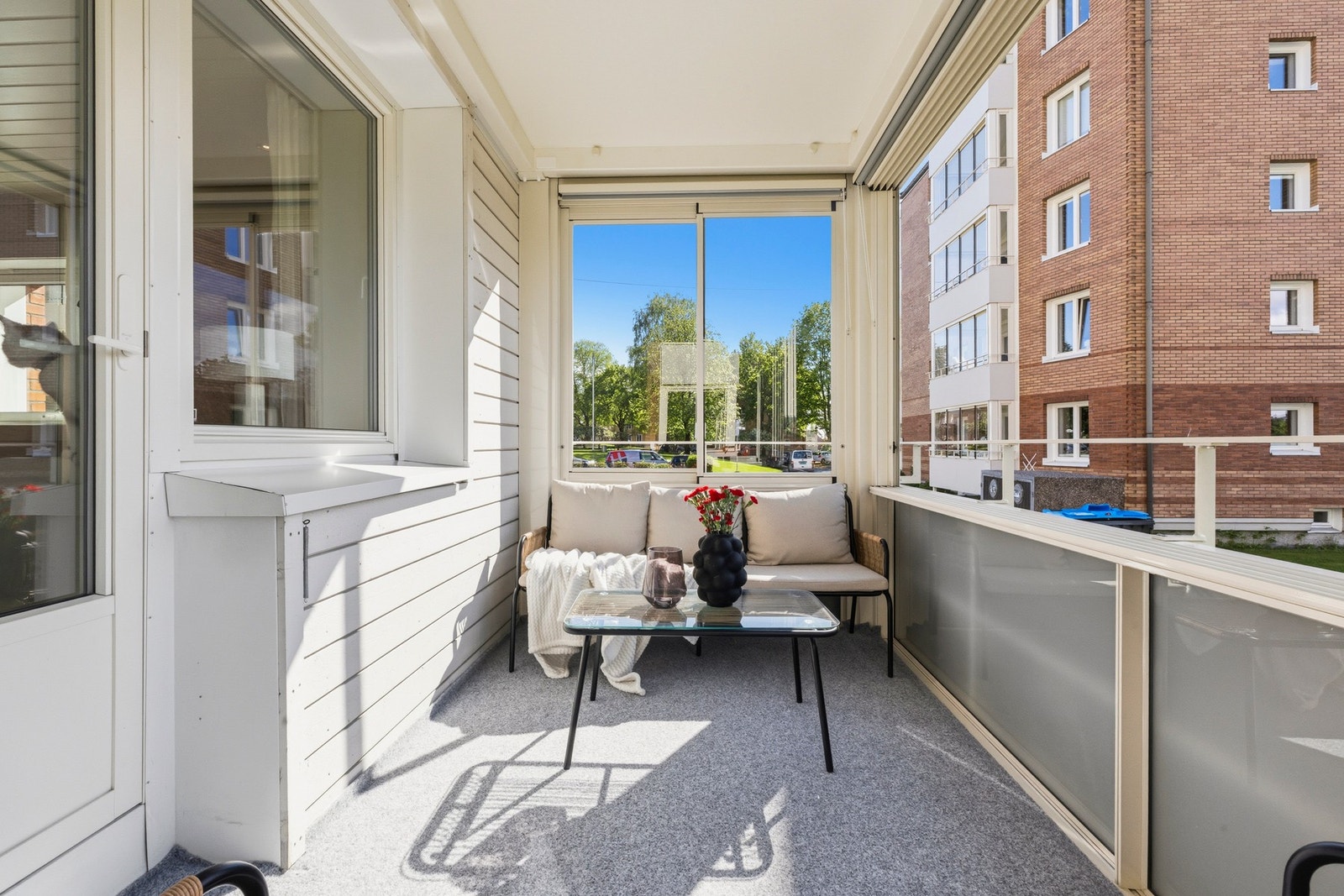 Koselig innglasset balkong med plass til utemøbler og grill. Galleribilde