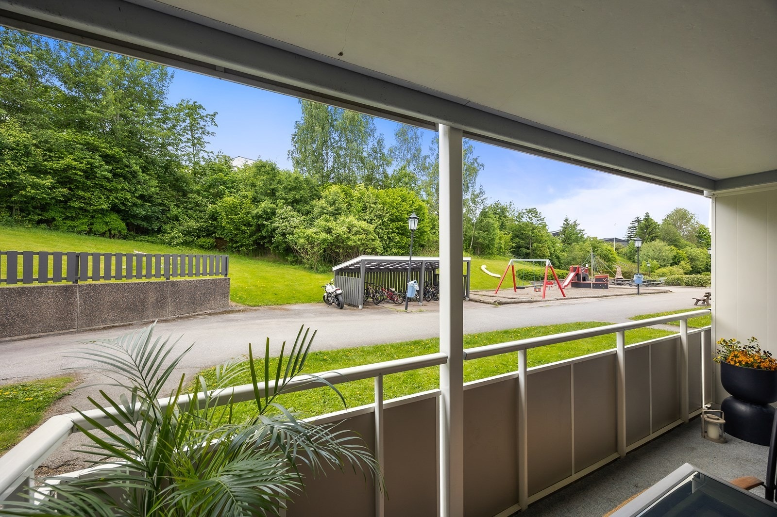 Fra balkongen er det utsyn over borettslagets grøntområder og lekeplass. Galleribilde