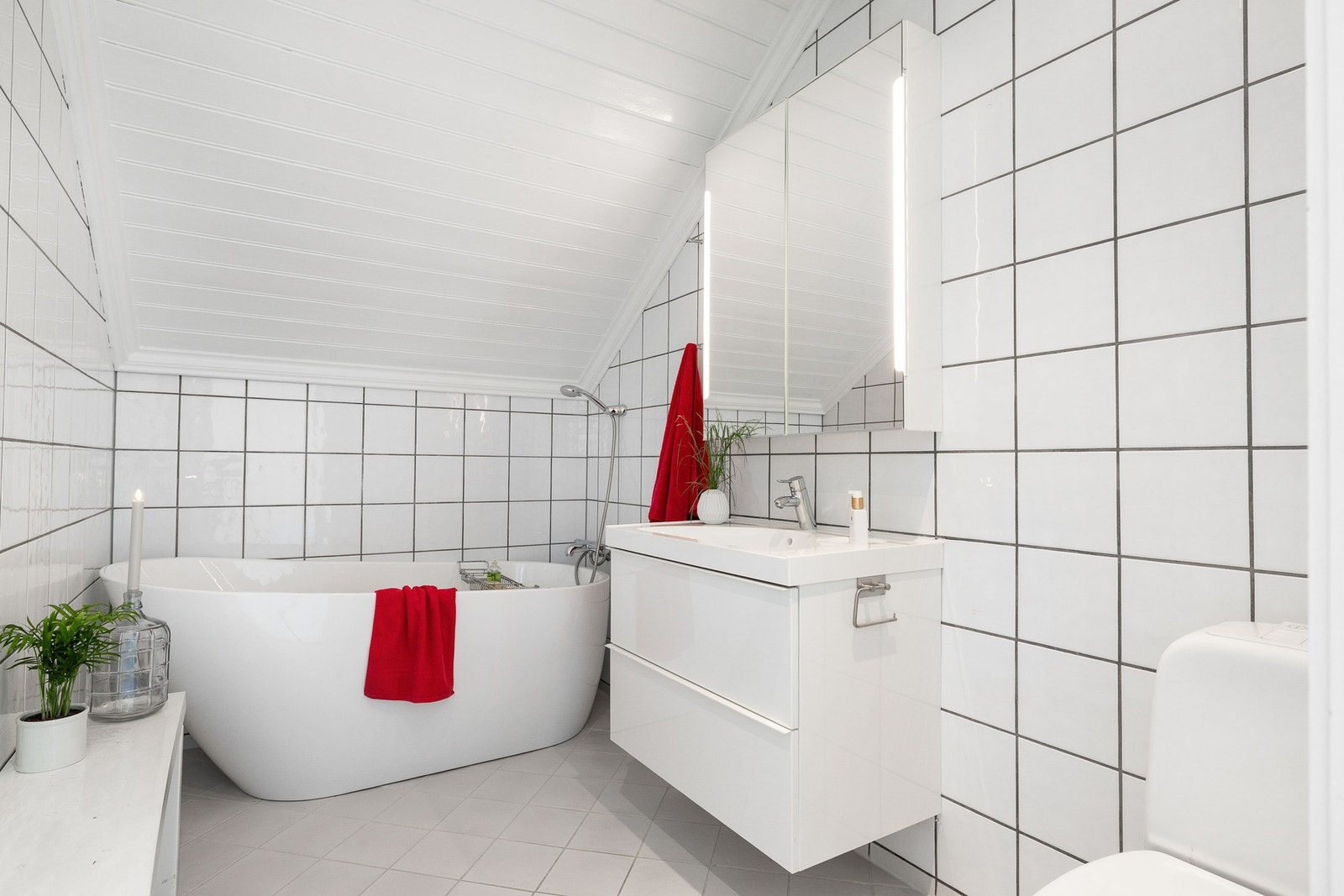 Romslig baderom med lekkert badekar, nedfelt servant med innredning og toalett. Badet ble pusset opp i 2013. Galleribilde