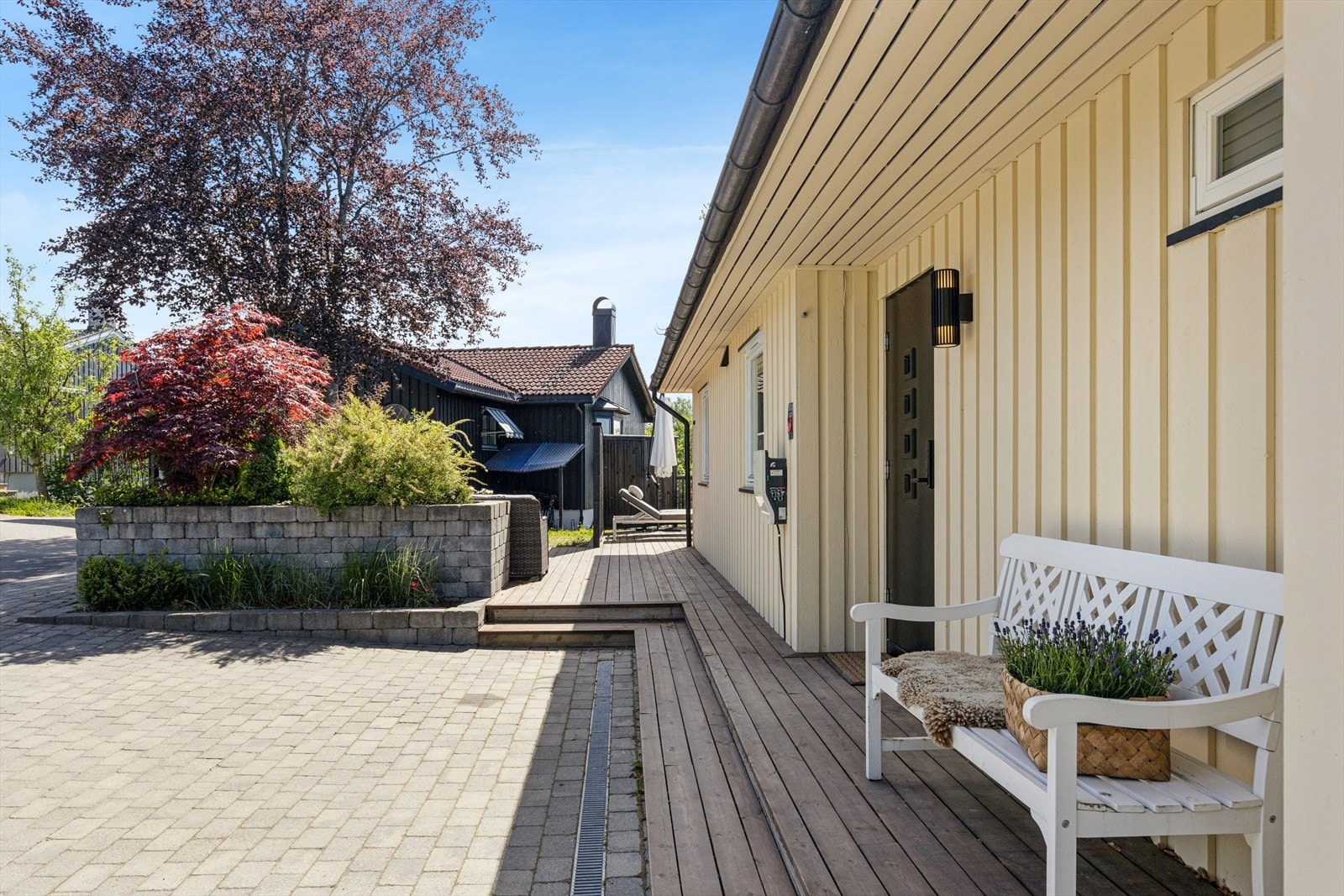 Tomten er pent opparbeidet med hage, belegningsstein og flere uteplasser. Galleribilde