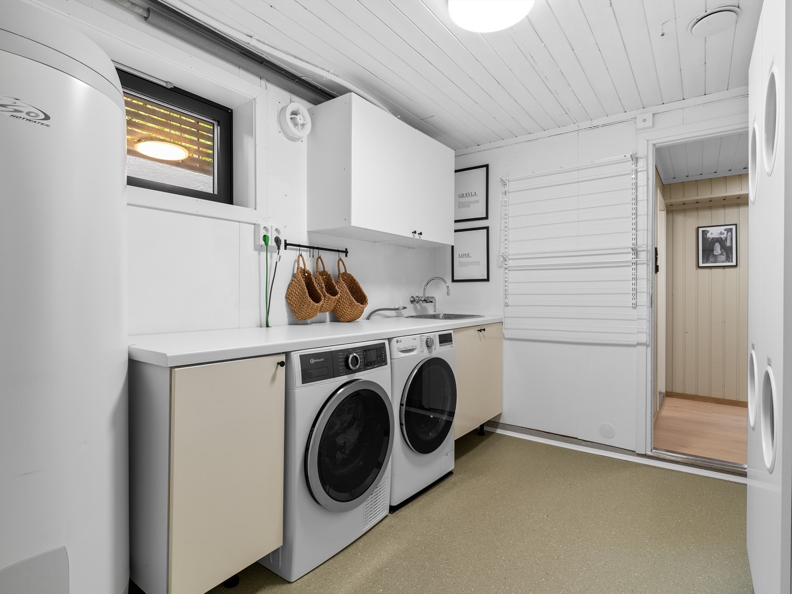 Praktisk vaskerom i kjelleren med vinylbelegg på gulvet, lagt i 2025. Galleribilde