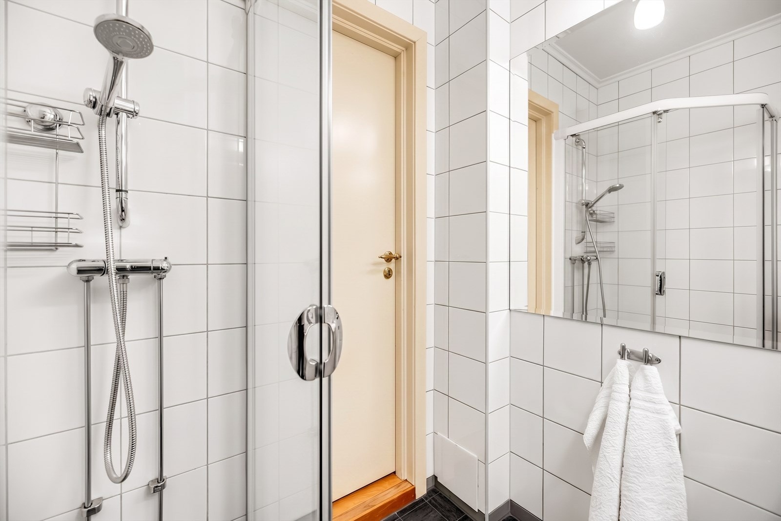 Badet er innredet med servant nedfelt i innredning og dusjhjørne med skyvedører. Det er elektrisk styrt vifte. Galleribilde