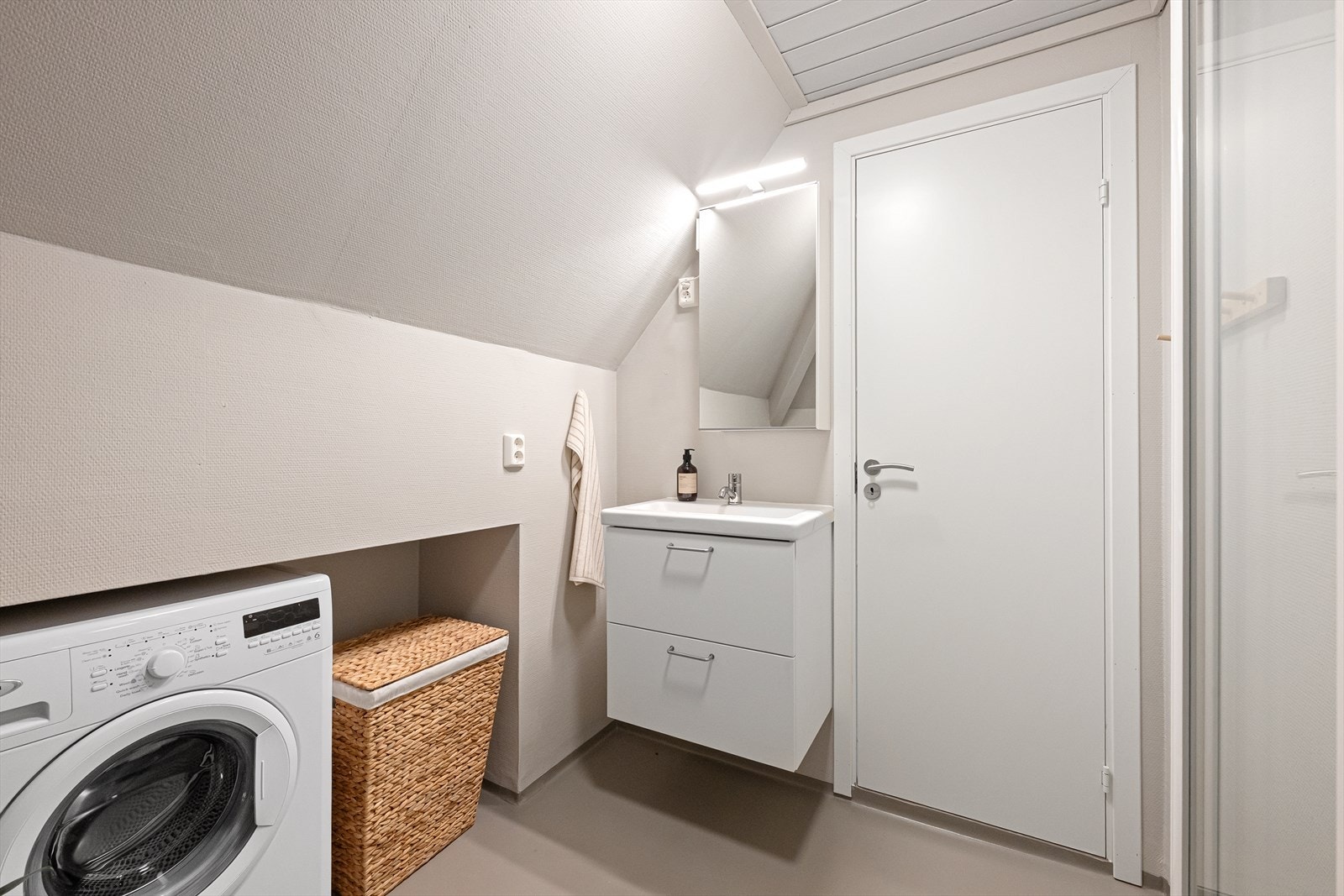 Badet på loftet har vinylbelegg på gulvet, dusjkabinett og opplegg for vaskemaskin. Galleribilde