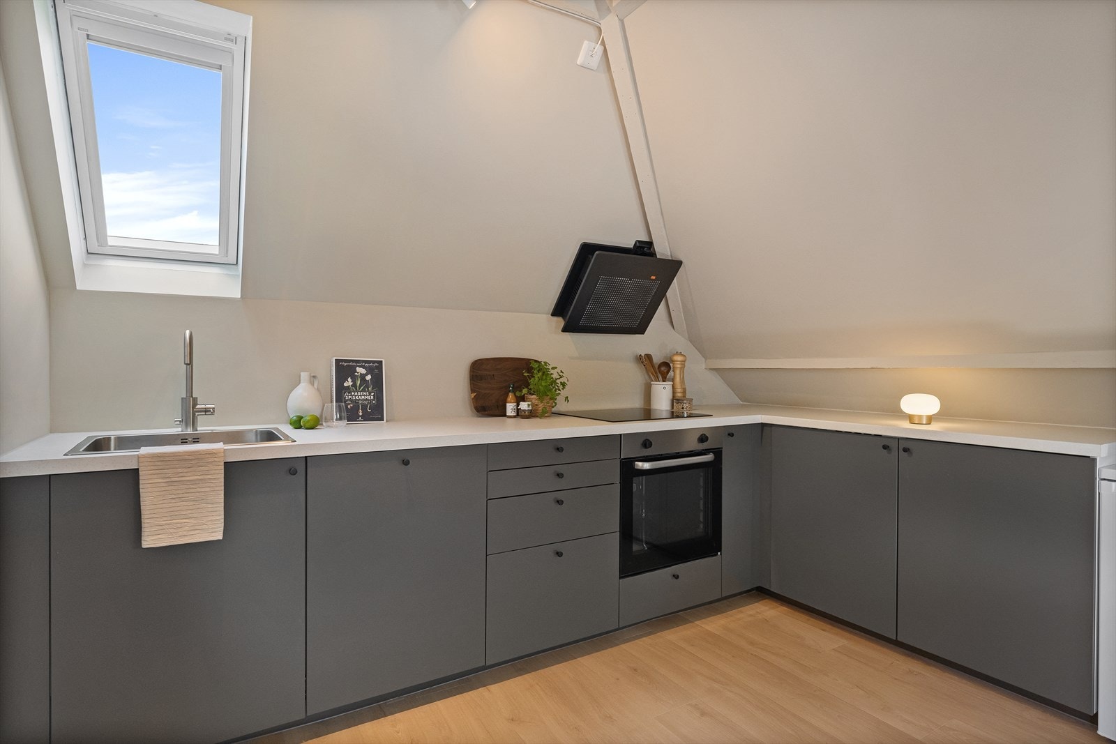 Kjøkkenet på loftet har innredning med glatte fronter, platetopp og stekeovn. Galleribilde