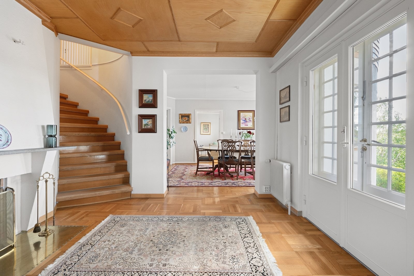 Hallen ønsker velkommen med en elegant, buet trapp, peis og utgang hage. Galleribilde