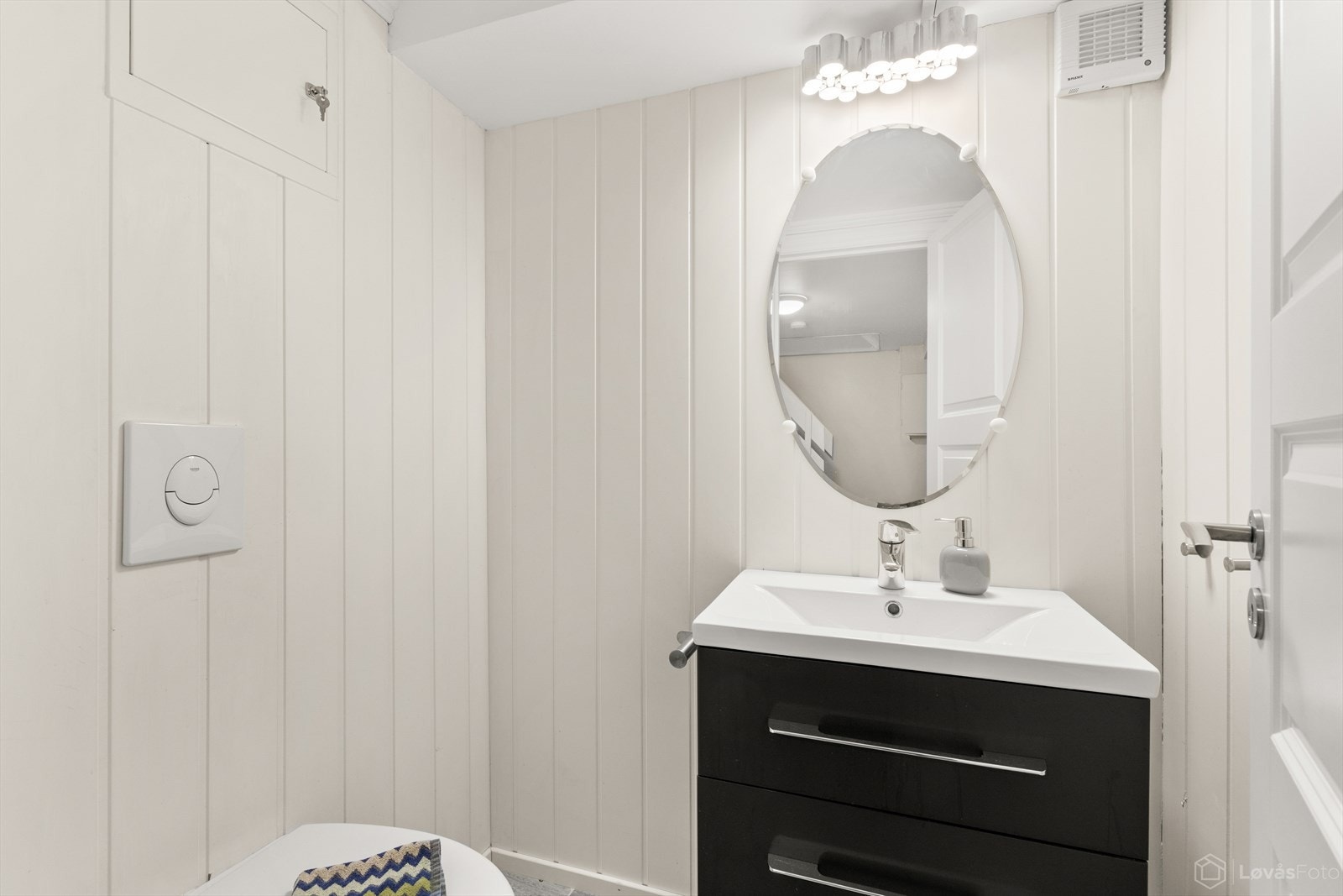 Lyst bad med toalett og servant med innredning. Galleribilde