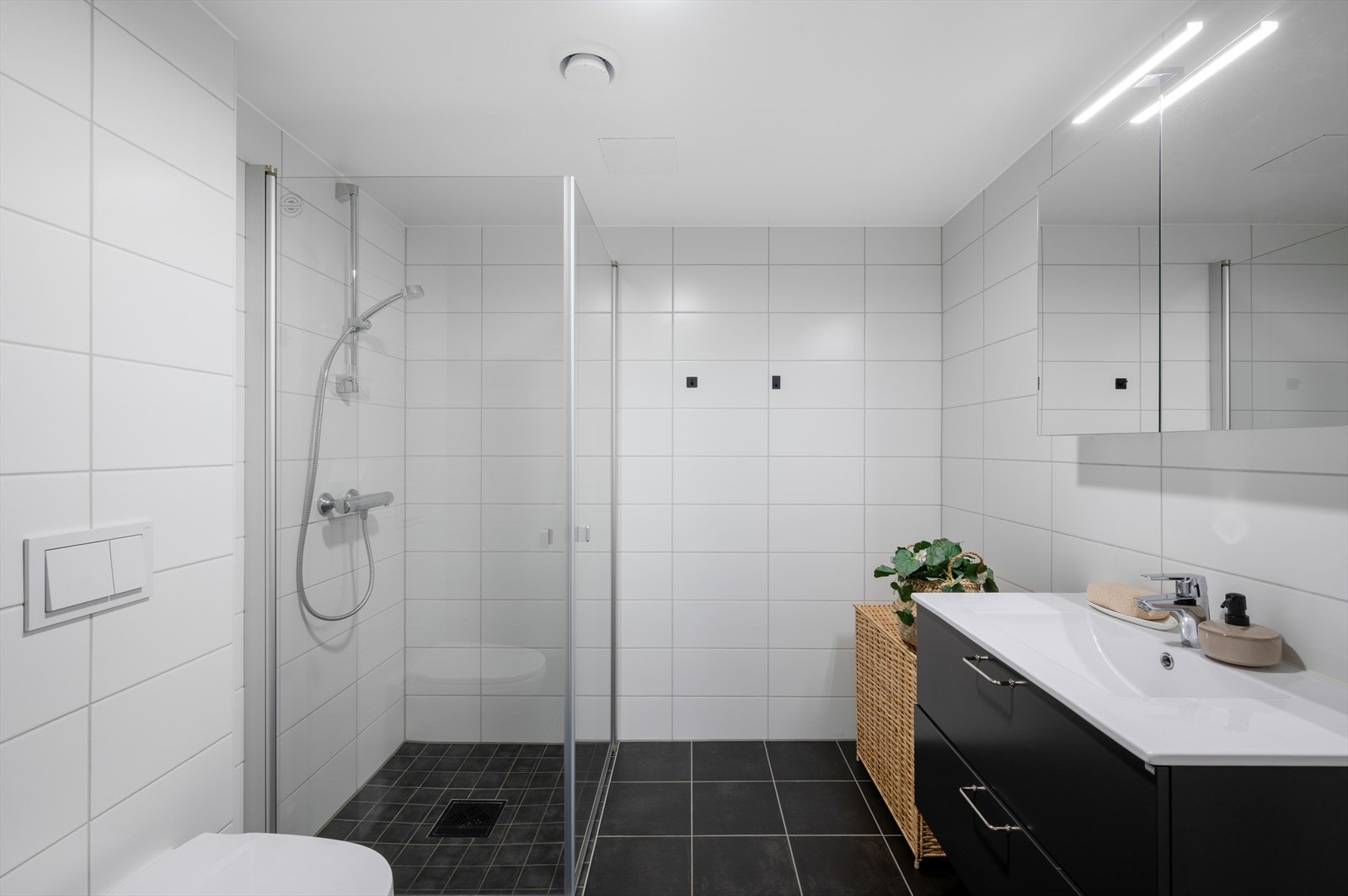- Badet inneholder vegghengt toalett, heldekkende servant, speilskap med belysning, dusjdører i glass og opplegg for vaskemaskin - Galleribilde