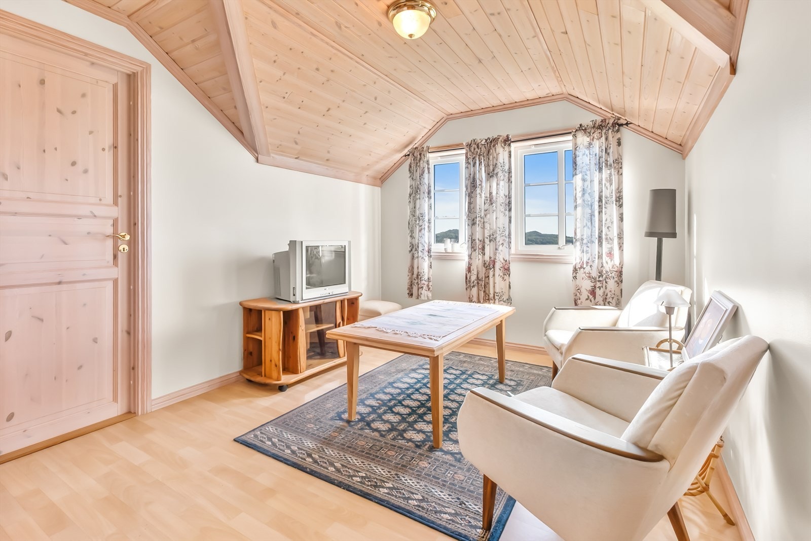Koselig loftstue med plass til en liten sittegruppe. Galleribilde