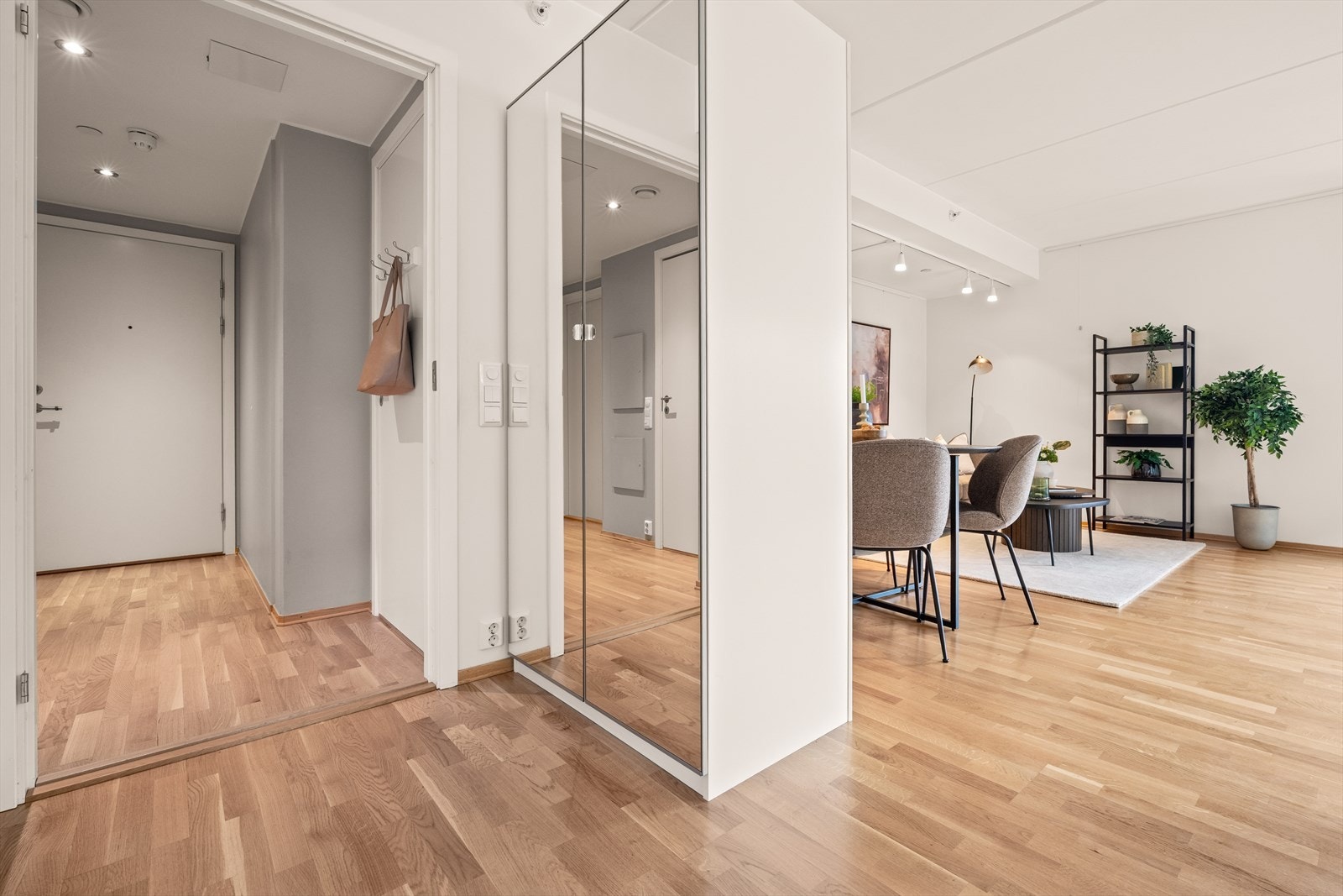 Entréen har plass til garderobeløsning og leder videre inn til leilighetens åpne oppholdsrom. Galleribilde