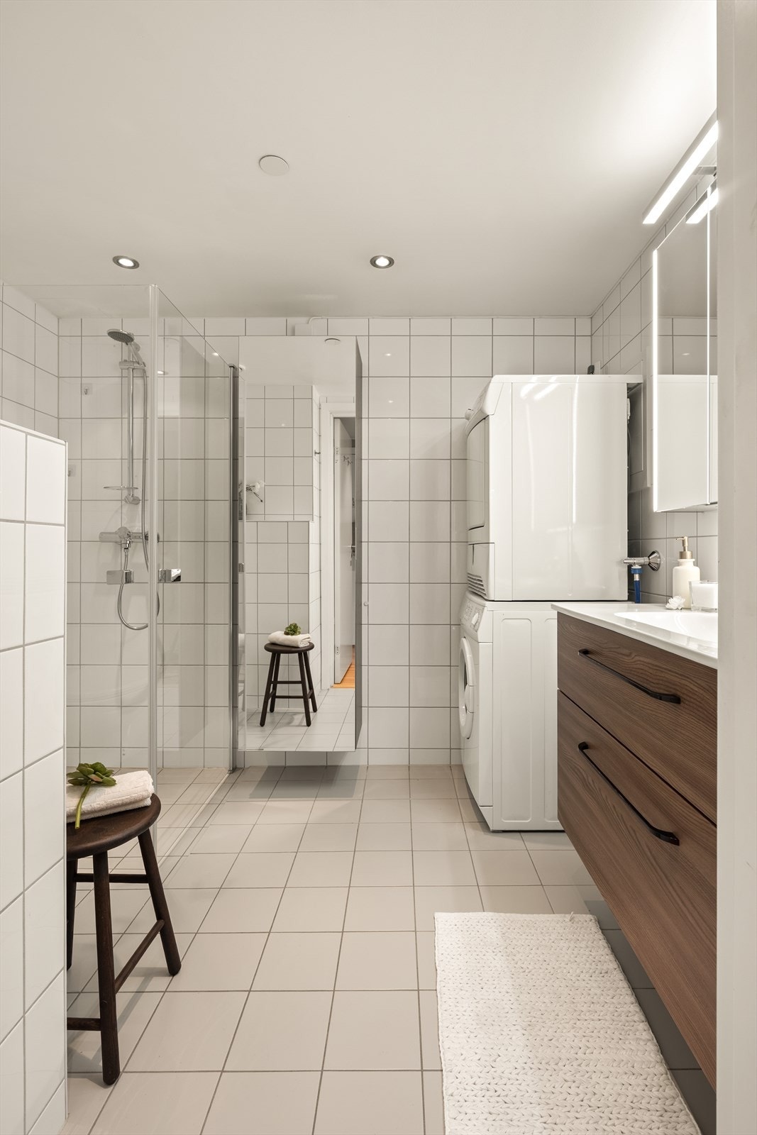 Badet er utstyrt med dusjhjørne med glassvegger, vegghengt toalett og servantinnredning. Galleribilde