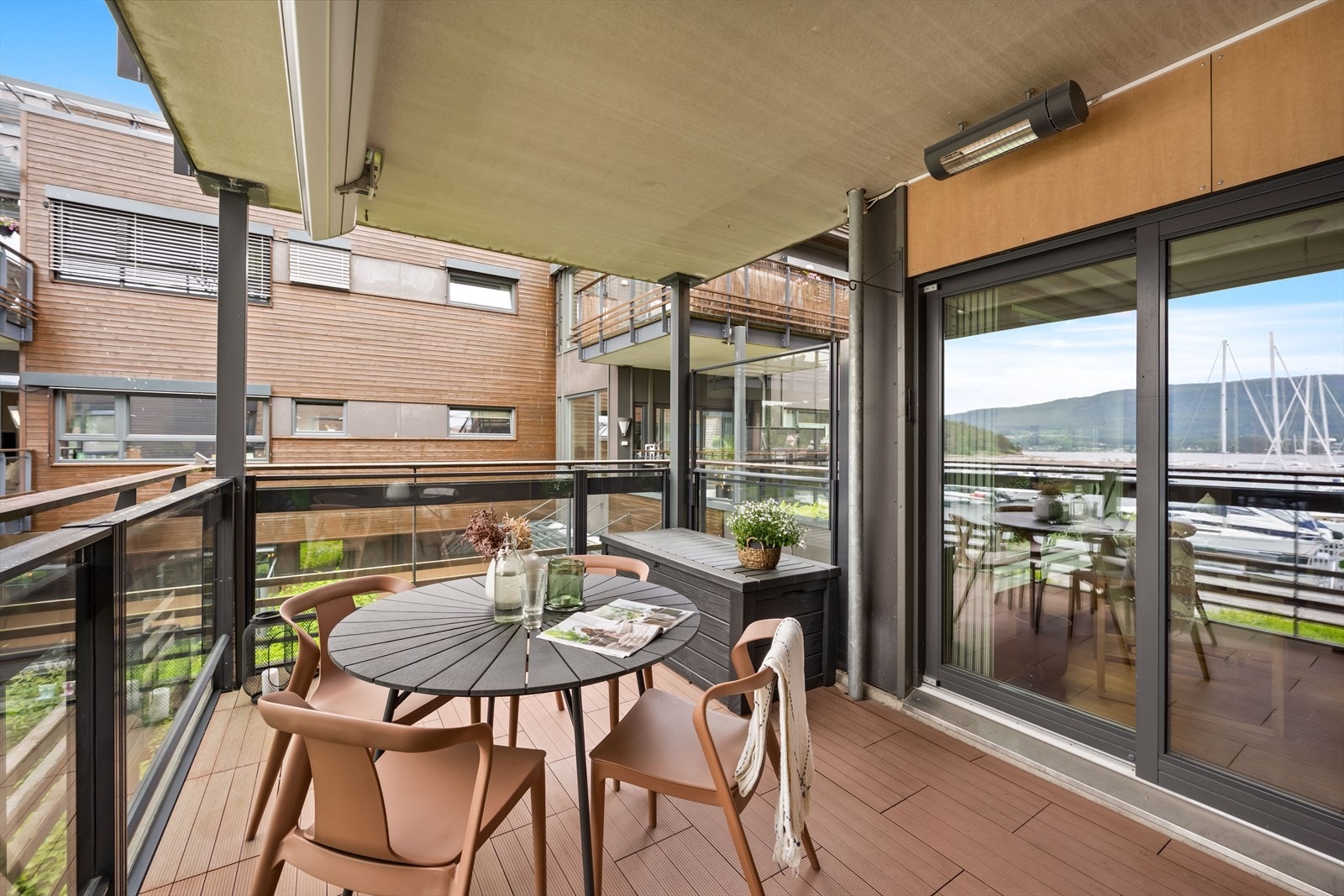 Den takoverbygde balkongen er oppgradert med heve- og senkbare glassfelt, elektrisk markise og terrassevarmer. Galleribilde