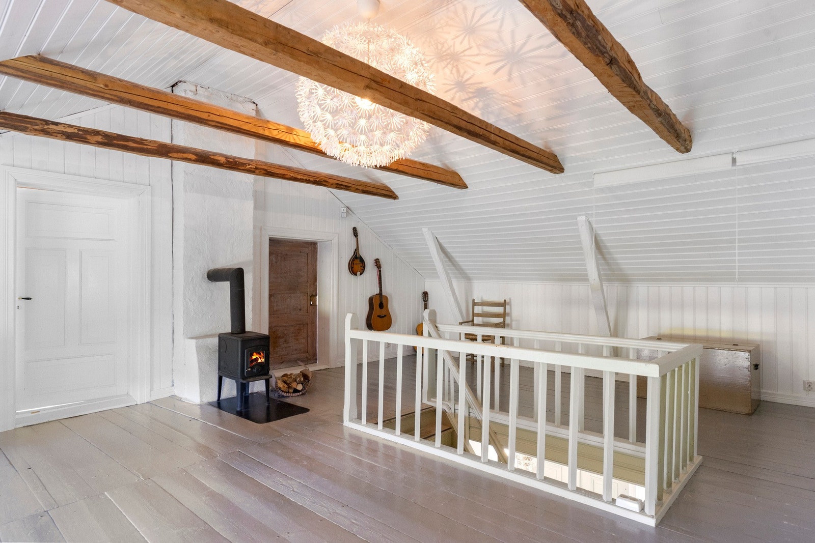 Den koselige loftstuen med vedovn er et lunt og innbydende oppholdsrom, perfekt for rolige kvelder med familien eller en god bok. Galleribilde