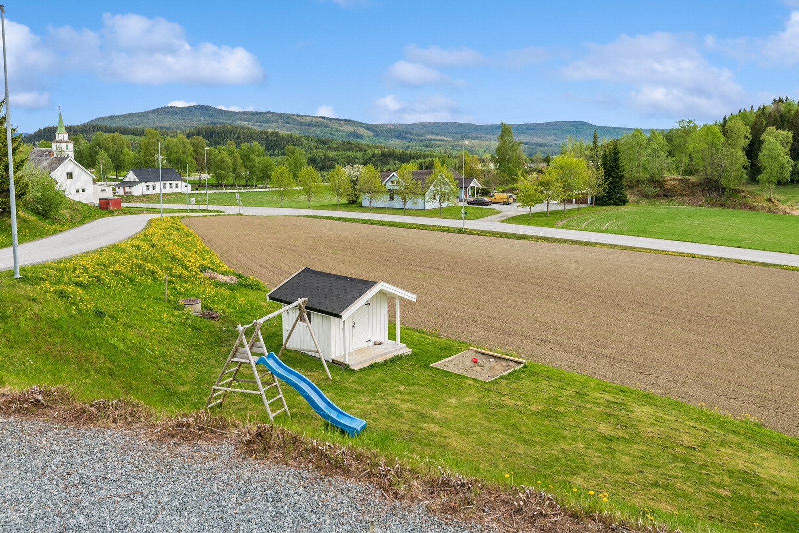 Romslig uteområde med mye boltreplass. Det er både lekestativ, sandkasse og lekehus på tomta. Galleribilde