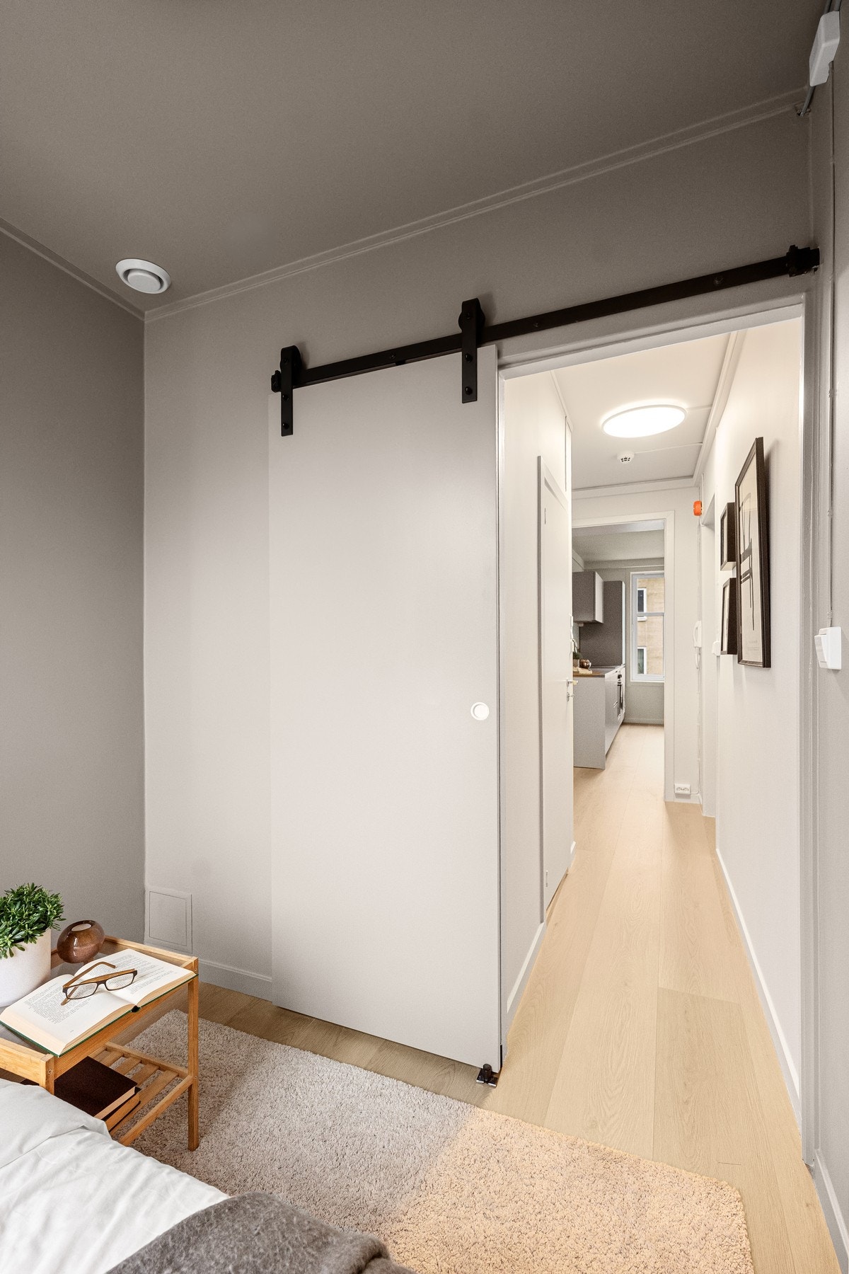 Soverommet har utenpåliggende skyvedørssystem i et stilig låvedør-design Galleribilde