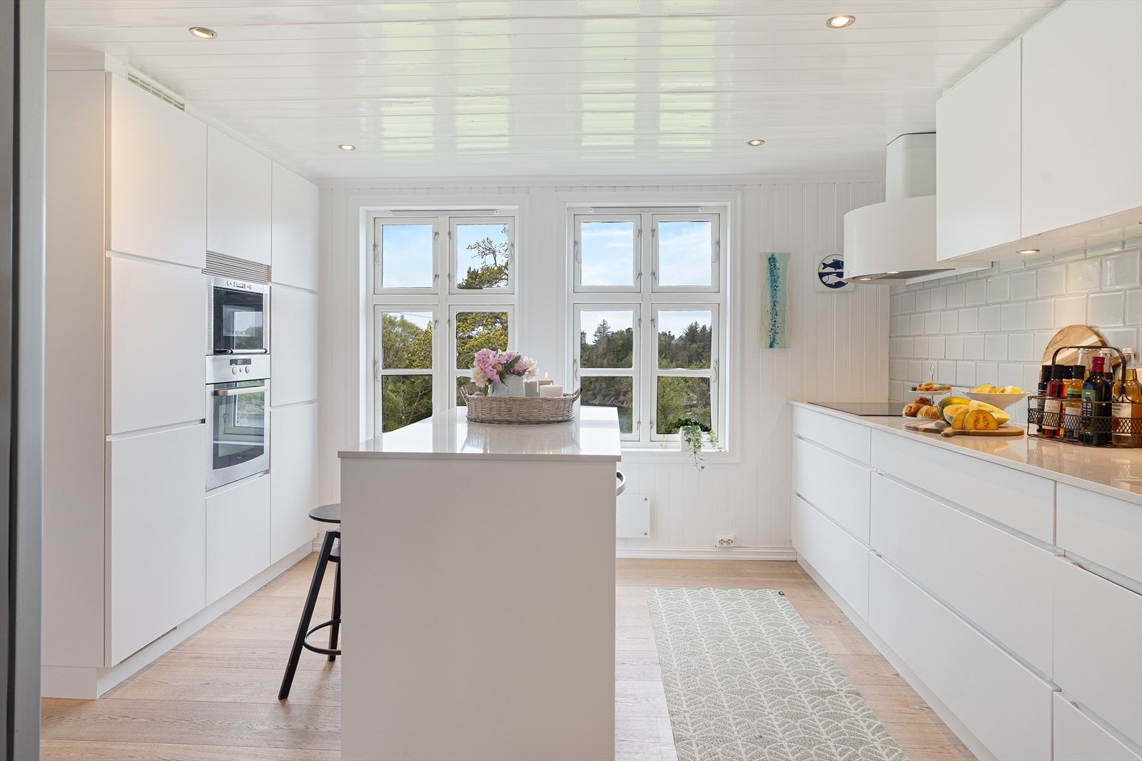 Moderne kjøkkeninnredning med stein benkeplate og integrerte hvitevarer. Galleribilde