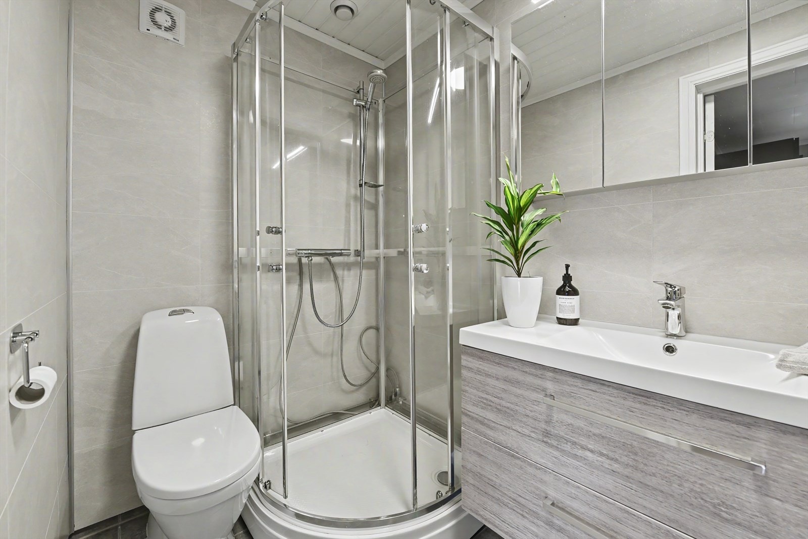 Badet i første etasje er utstyrt med servantmøbel, toalett og dusjkabinett. Galleribilde