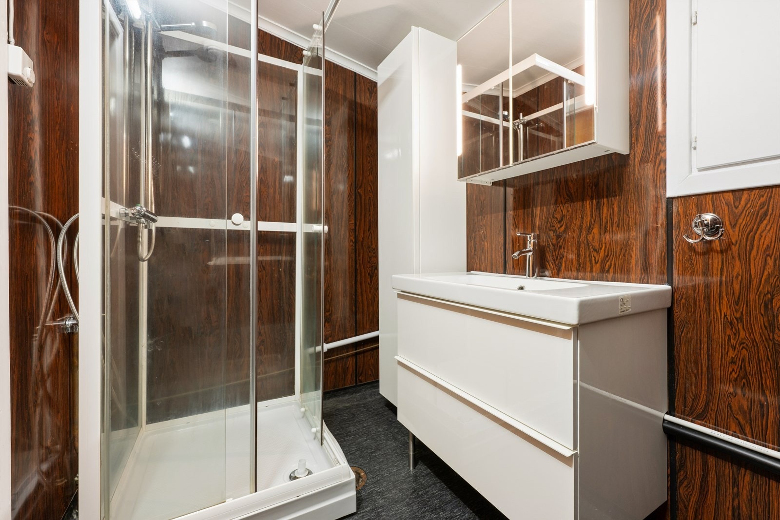 Badet er fra byggeåret og er utstyrt med dusjkabinett og servant med skap. Galleribilde