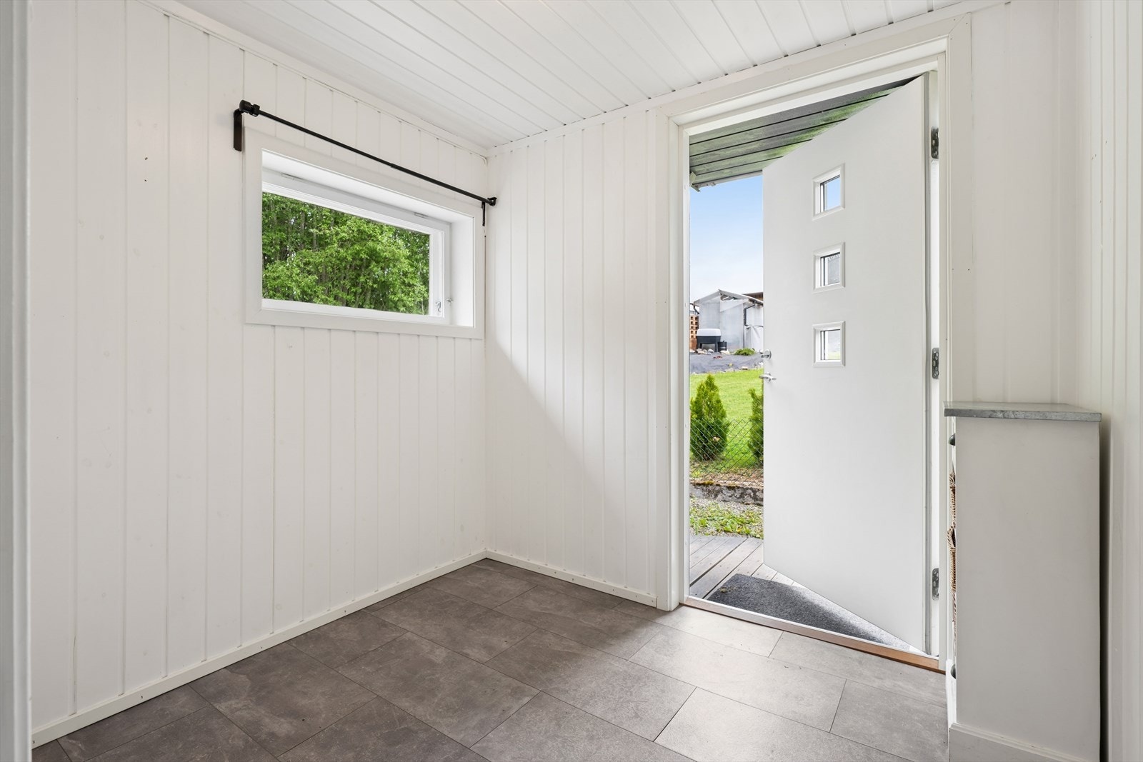 Det lyse og innbydende vindfanget ønsker velkommen inn i boligens 1. etasje. Ytterdøren er fra 2016, og i rommet er det god plass til oppbevaringsmøbel. Galleribilde