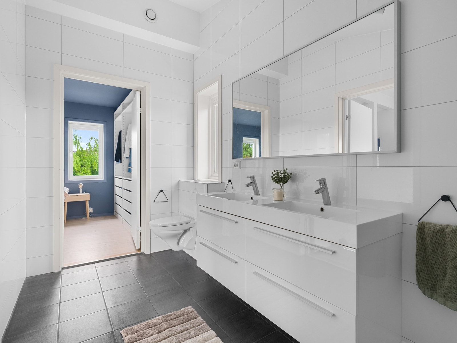Badet i andre etasje er helfliset med gulvvarme. Badet er innredet med dobbel servant på skuffeseksjon og speil. Galleribilde