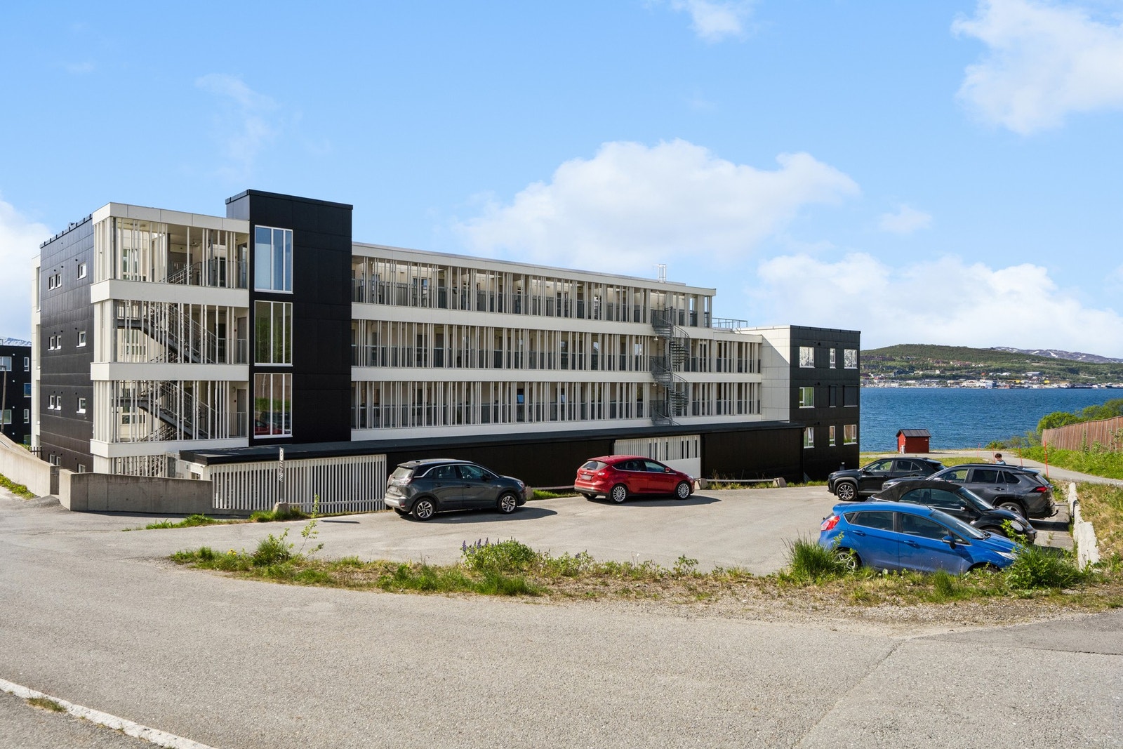 Asfaltert parkeringsplass for beboere og gjester ved bygget. Galleribilde