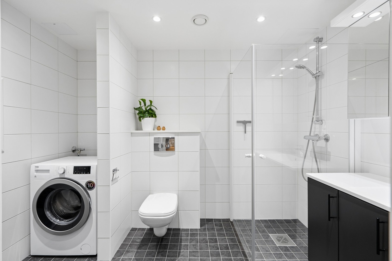 I en praktisk nisje på badet er det opplegg for vaskemaskin. Galleribilde