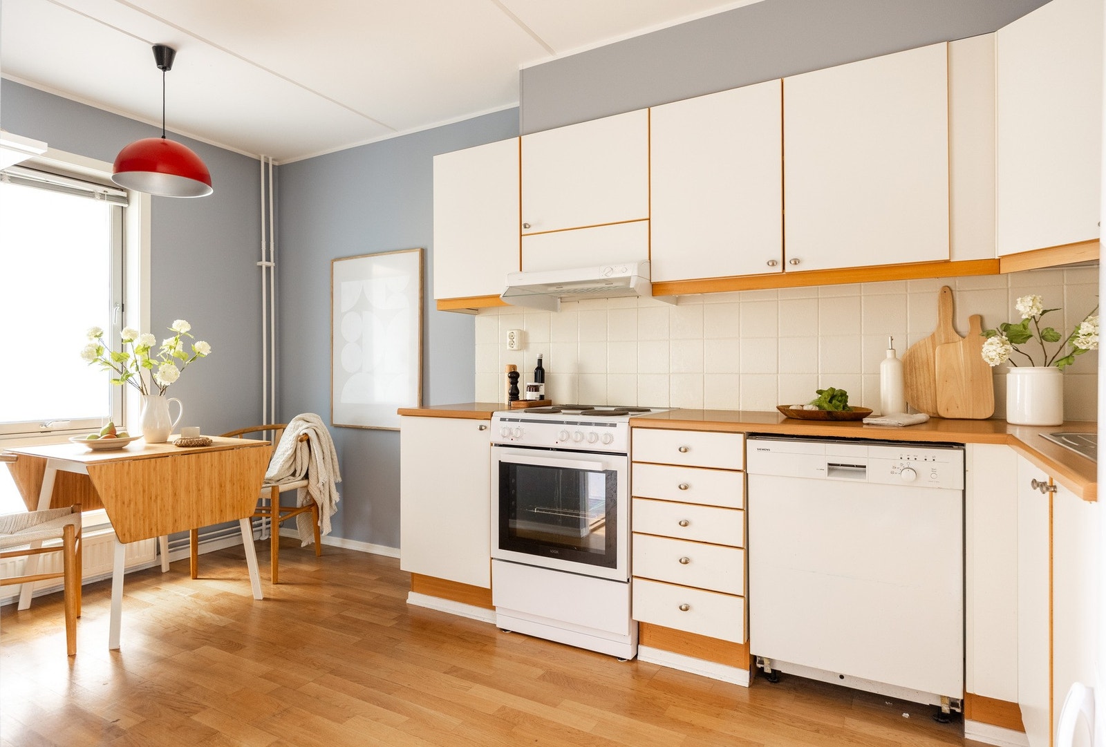 Kjøkkeninnredningen har glatte lyse fronter og benkeplater av laminat. Galleribilde