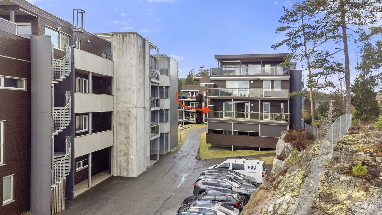 Leilighetsbygget ligger i et pent opparbeidet område med gress og beplantning. Galleribilde