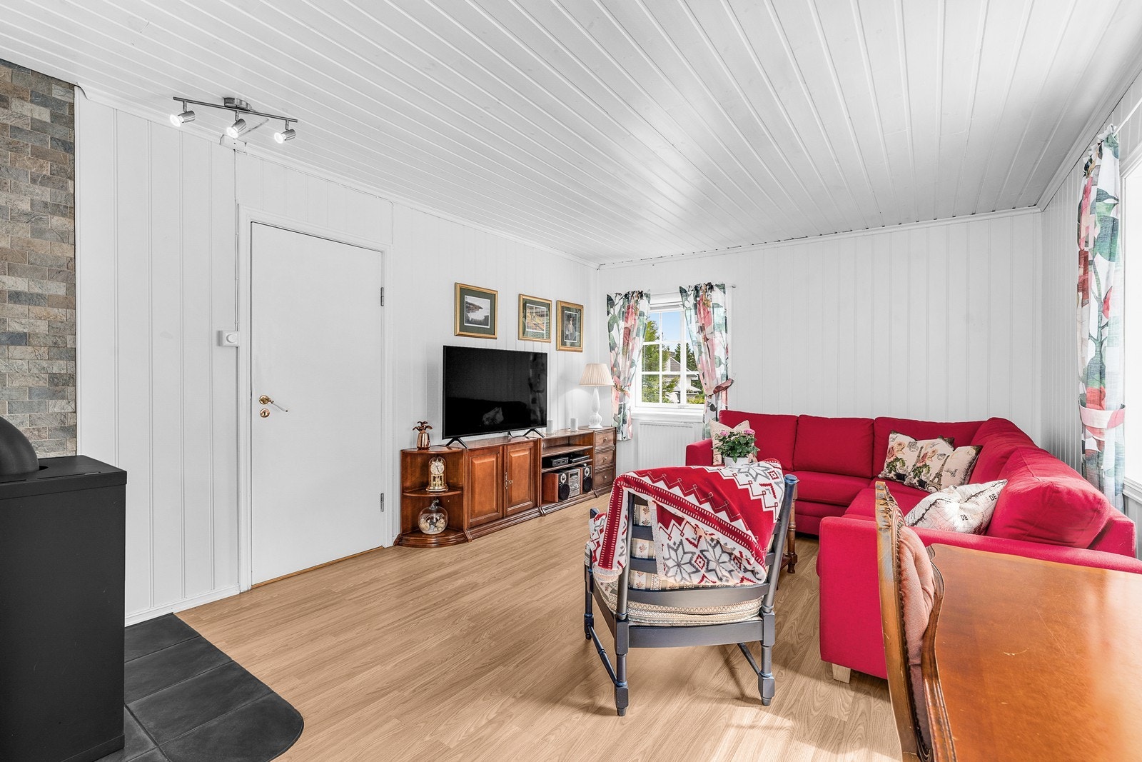 Lyse panelvegger og tak gir en gjennomgående stil i oppholdsrommene. Galleribilde