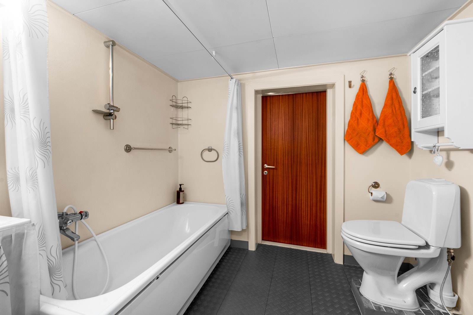Badet inneholder toalett, servant og badekar med dusjløsning. Galleribilde