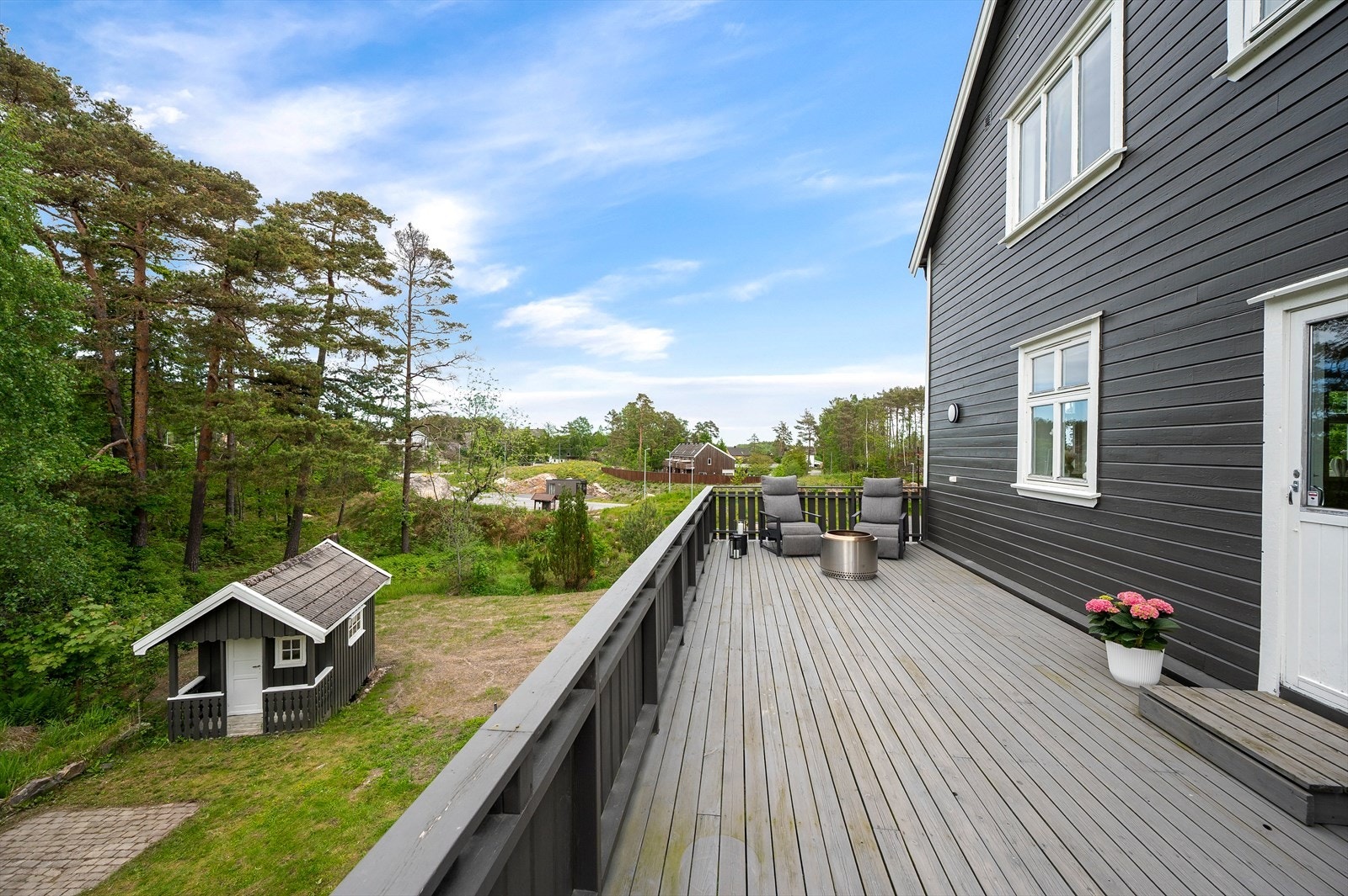 Verandaen har god plass til flere sittegrupper og utsikt over den store tomten. Galleribilde