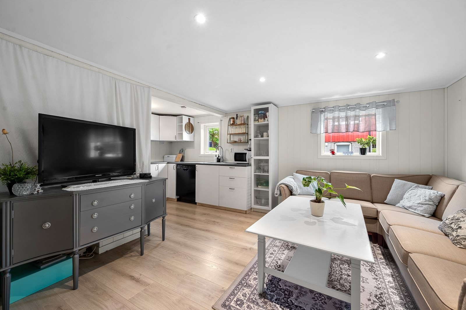 Den åpne løsningen i kjelleren gir plass til både sofagruppe og en kjøkkenkrok. Galleribilde