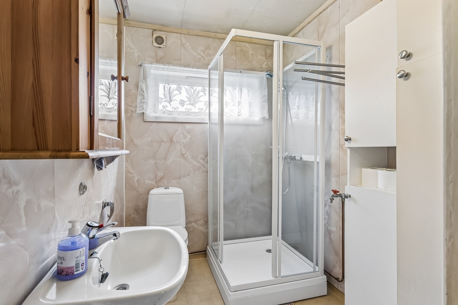 Badet i første etasje er utstyrt med dusjkabinett, toalett og servant med speilskap. Galleribilde