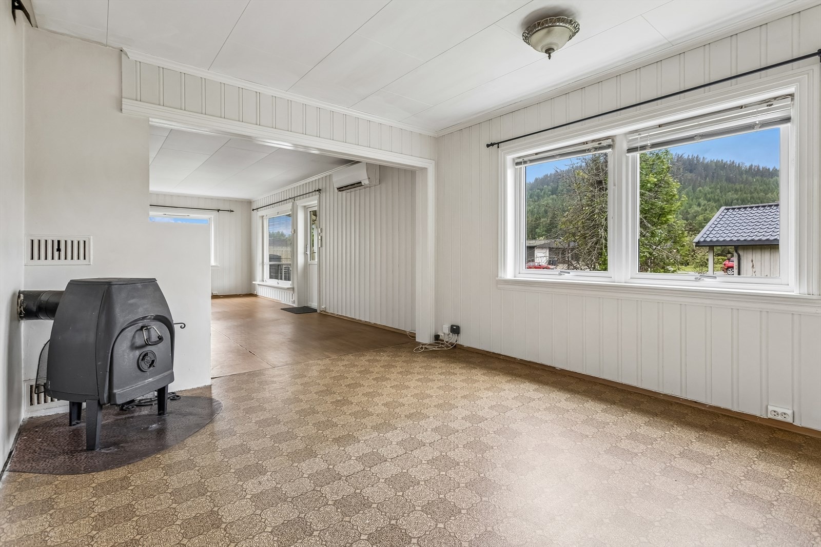 Rommet har vegger kledd med trepanel og malte plater. Galleribilde