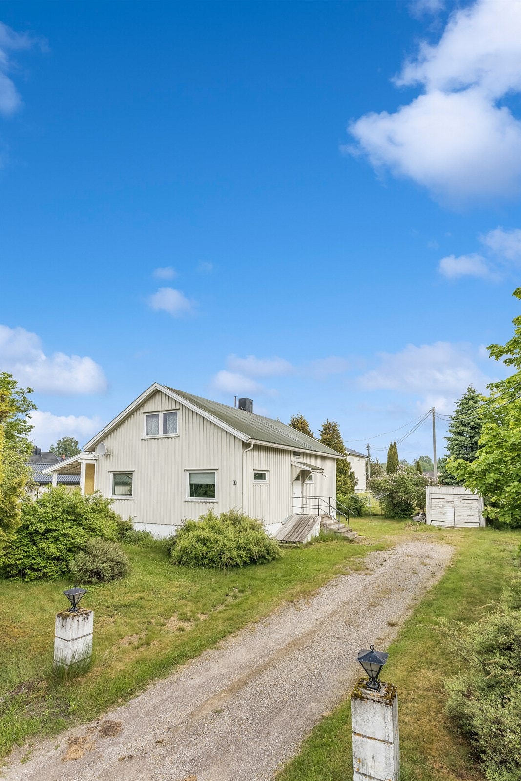 Enebolig fra 1956 over tre plan med en stor, flat tomt og to garasjebygg. Galleribilde