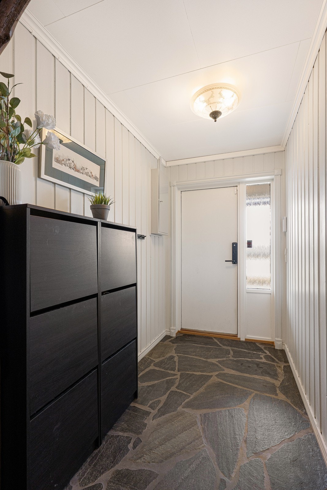 Entréen ligger i underetasjen og har rustikk skifer på gulvet, noe som står fint til de lysmalte veggflatene. Galleribilde